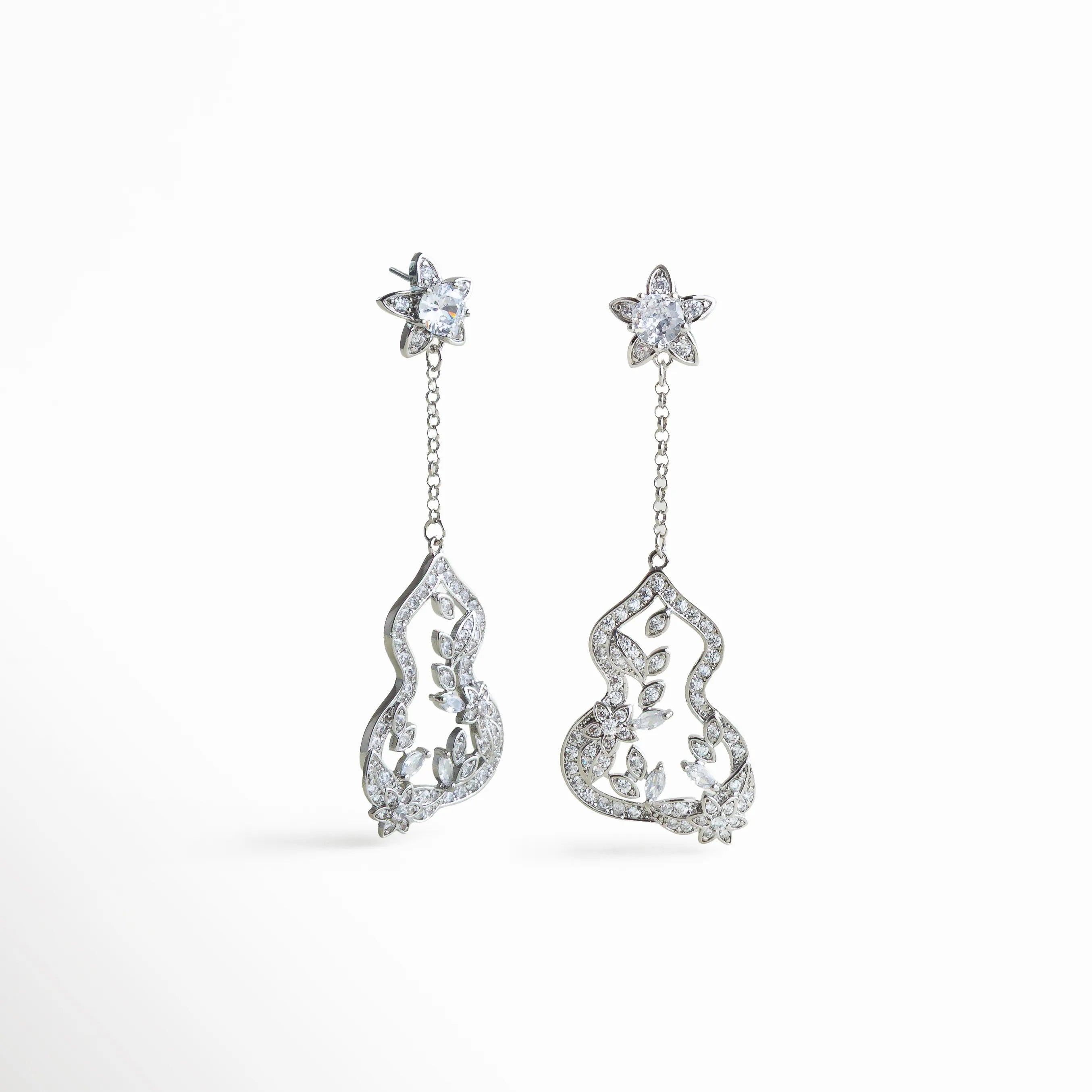 Aretes plateados largos con diseño floral colgante, adornados con zirconias brillantes en forma de hoja y flor, elegantes y sofisticados.
