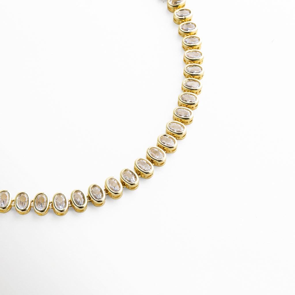 Segmento de collar con zirconias y acabado en oro brillante, Parte del collar mostrando detalles de piedras y estructura, Vista cercana de collar elegante con zirconias, Fragmento de cadena dorada con incrustaciones brillantes, Detalle parcial de collar con diseño sofisticado