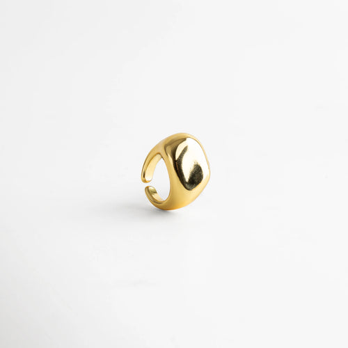 Anillo dorado ajustable con acabado pulido tipo espejo, diseño contemporáneo de superficie curva y bordes suaves que reflejan la luz con elegancia.