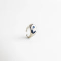Anillo plateado ajustable con acabado pulido tipo espejo, diseño contemporáneo de superficie curva y bordes suaves que reflejan la luz con elegancia.