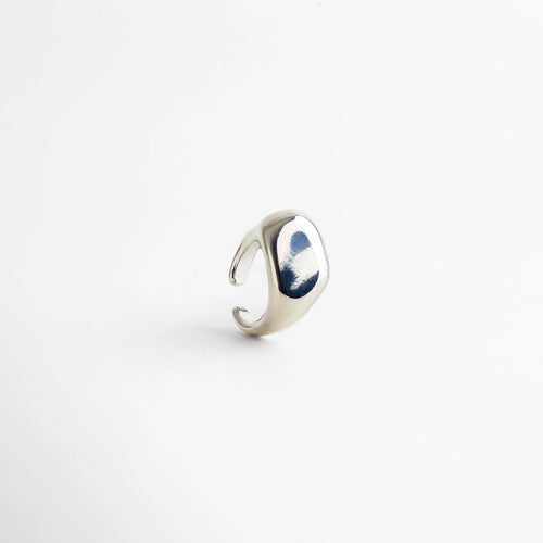 Anillo plateado ajustable con acabado pulido tipo espejo, diseño contemporáneo de superficie curva y bordes suaves que reflejan la luz con elegancia.