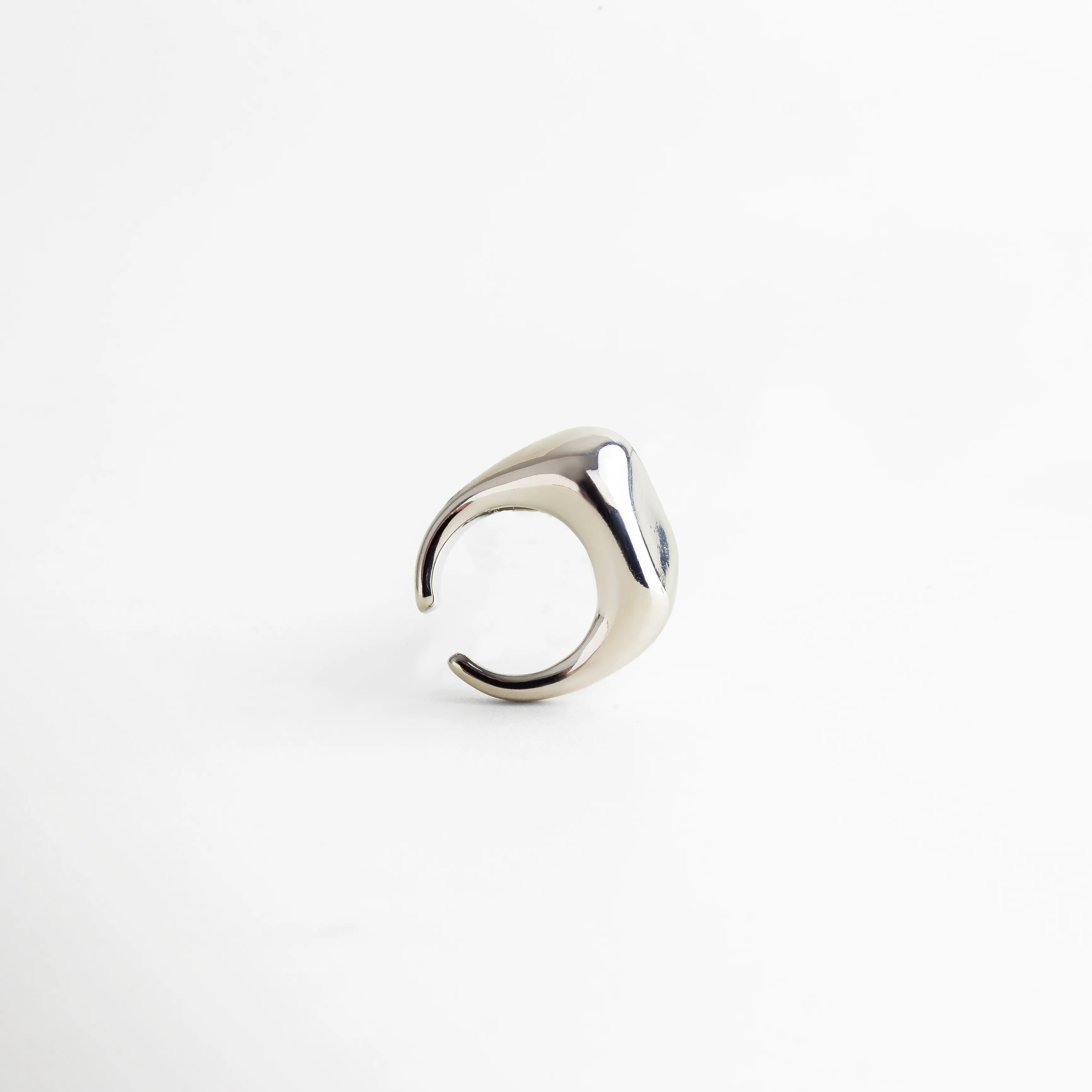 Anillo plateado abierto con forma orgánica y estilo moderno, acabado brillante que realza su diseño minimalista y sofisticado.