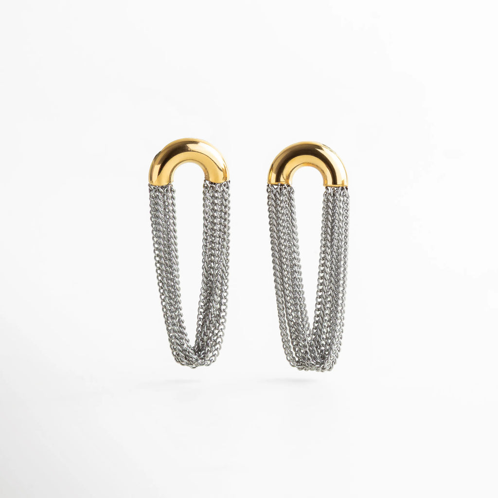 Aretes bicolor con parte superior dorada en forma de media herradura y cadenas plateadas colgantes, diseño moderno y estructural con acabado brillante.