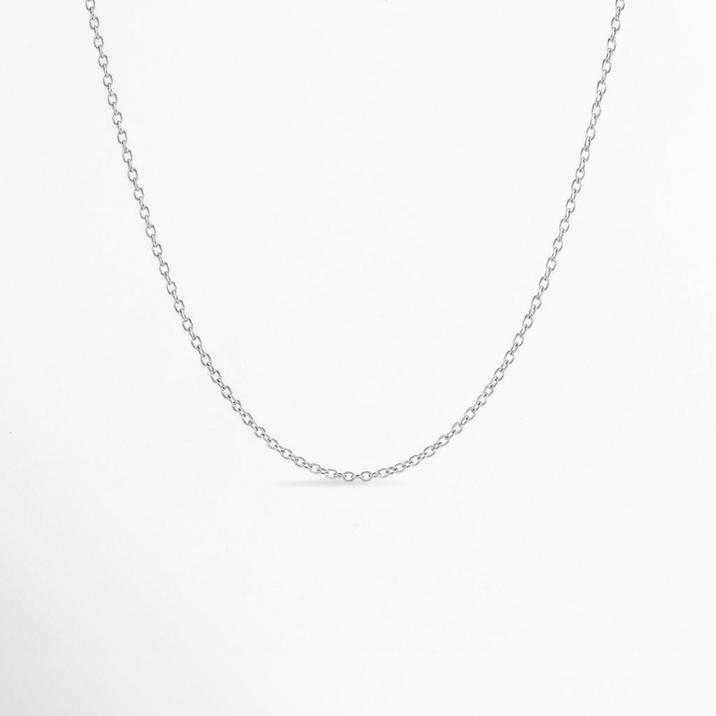 Cadena Simple Plateada de eslabones finos tipo forzatina/cable en tono plata con pulido brillante, vista frontal suspendida sobre fondo blanco, Cadena fina plateada de 45 cm de estilo minimalista enchapada en oro blanco o rodio, Vista de frente de collar de eslabones delgados y delicados en tono plata sobre superficie clara, Cadena básica plateada ajustable ideal para dijes y charms en toma de plano medio.