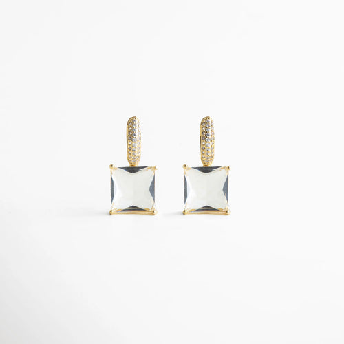 Vista frontal pareja de los aretes mostrando simetría perfecta: argolla pavé dorada y cristal cuadrado suspendido. Su estética pulida y minimalista aporta glamour sin esfuerzo, ideal para elevar un outfit de noche o un look más chic de día.