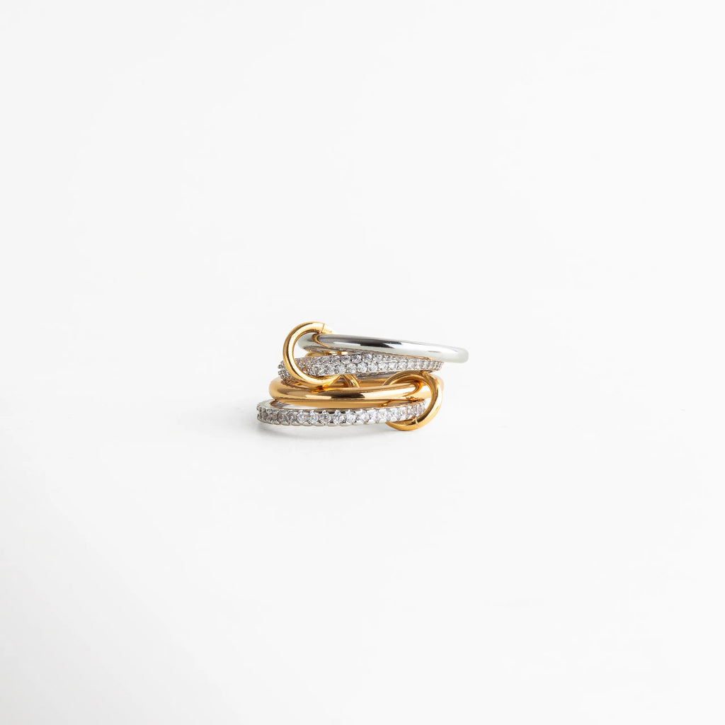 Anillo bicolor dorado y plateado con diseño entrelazado de líneas curvas, joyería moderna y elegante para mujer con acabado pulido.