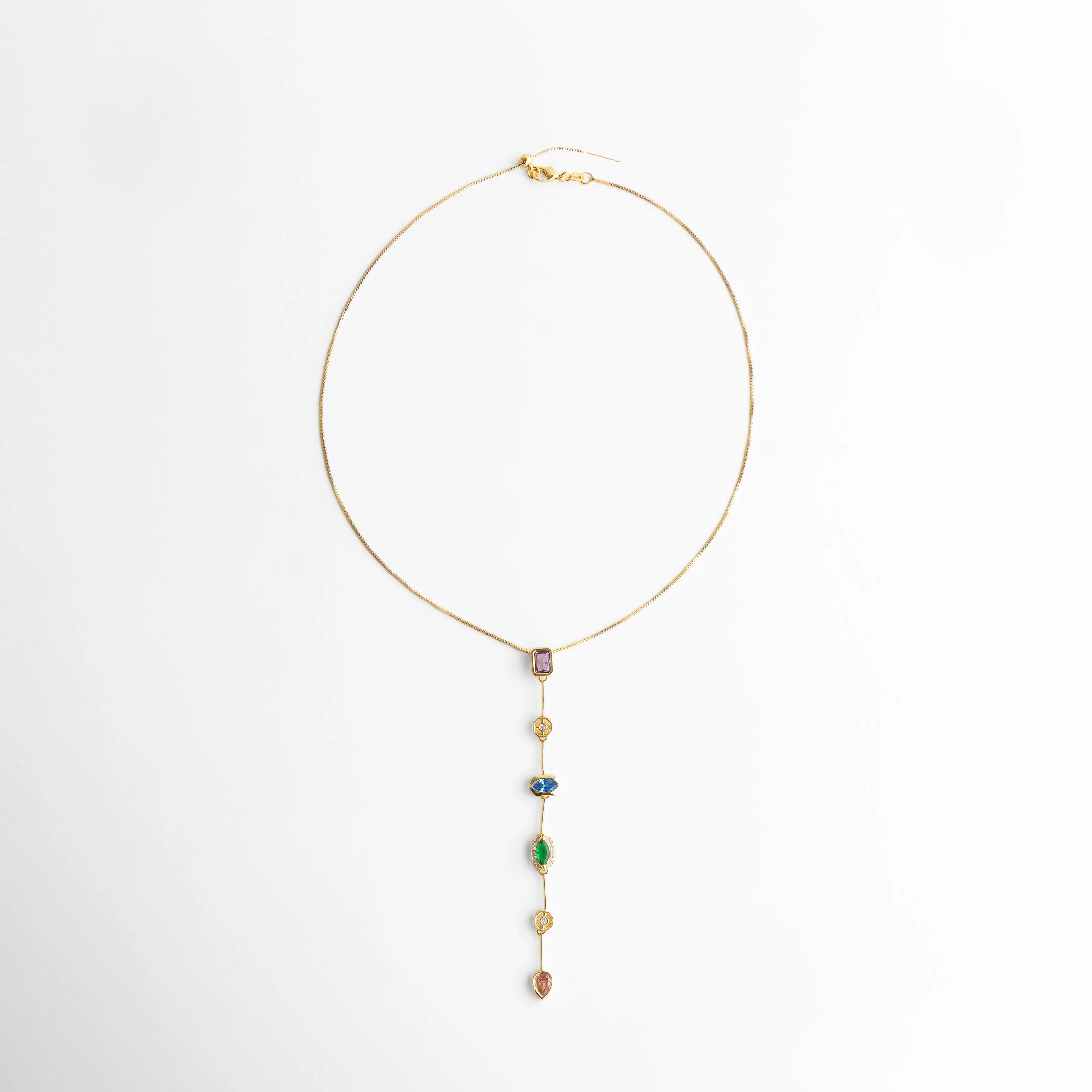 collar lariat vista superior, joyería dorada con gemas, collar largo elegante mujer, accesorio moderno colorido, collar minimal chic, joyería femenina de colores, collar dorado estilizado, collar delicado mujer