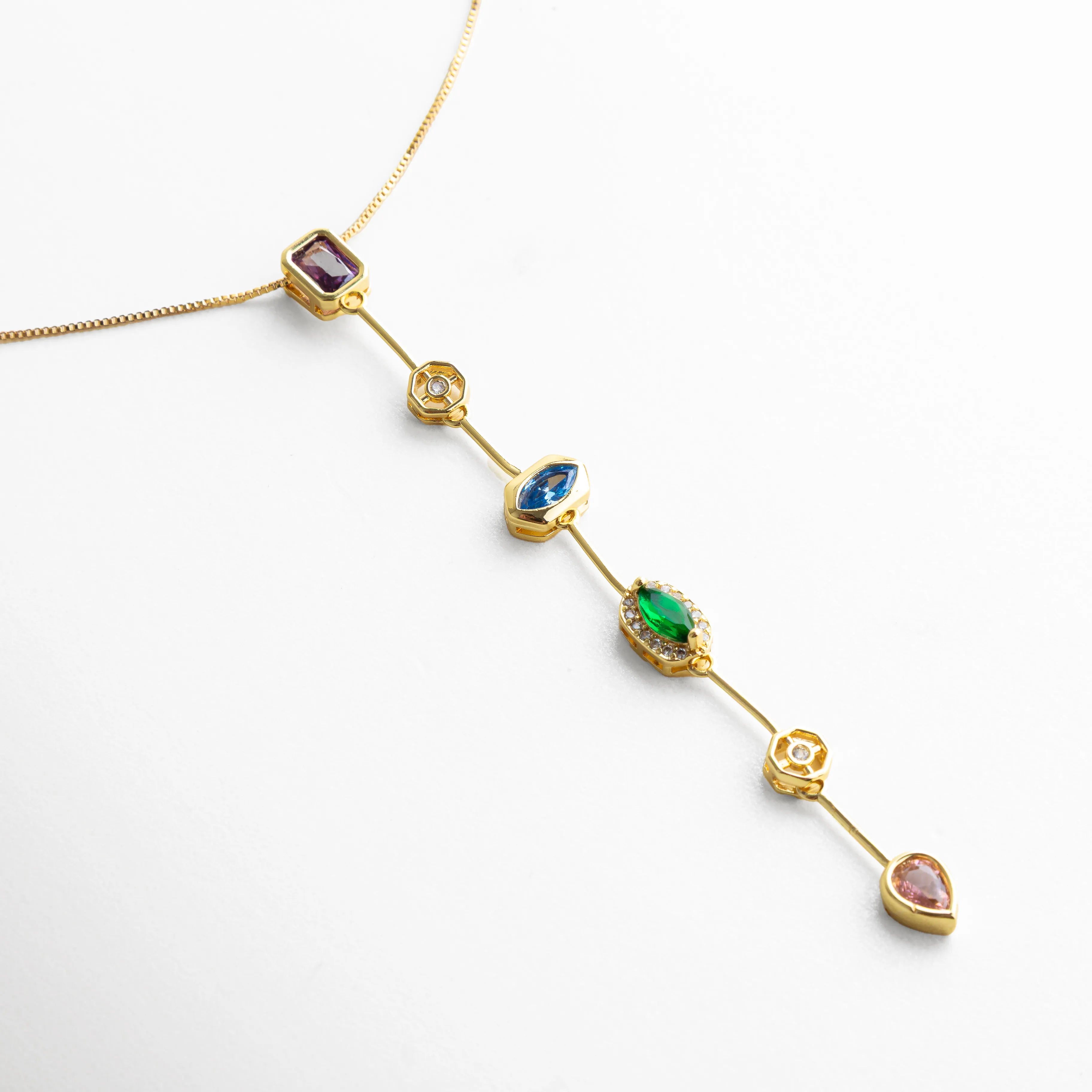 detalle collar lariat, gemas de colores joyería, collar dorado elegante, accesorio colorido moderno, collar femenino con piedras, joyería delicada dorada, collar con caída larga, piedras multicolor collar
