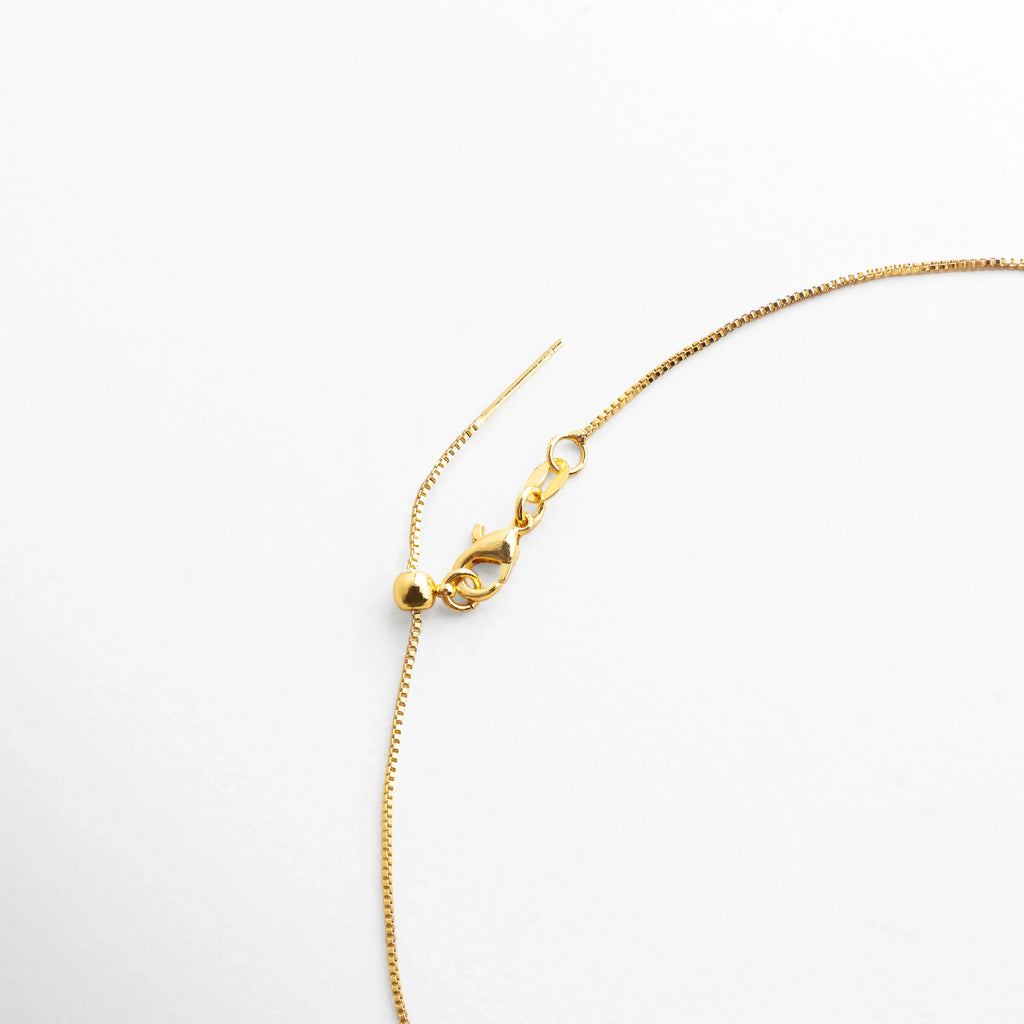 cierre collar dorado, cadena de extensión collar, detalle joyería dorada, accesorio elegante mujer, collar lariat diseño fino, joyería dorada moderna, detalle de cierre collar, collar delicado dorado