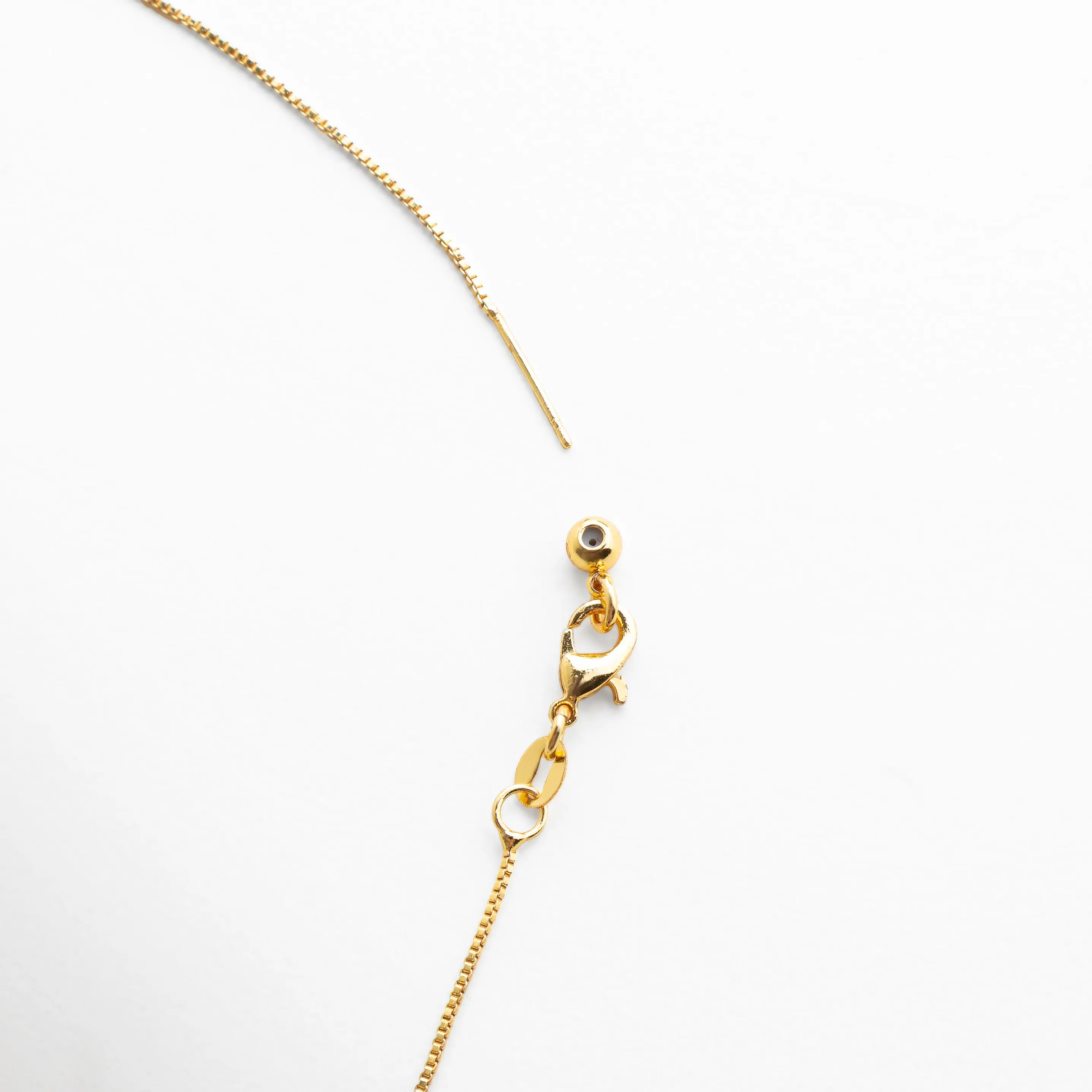 detalle collar lariat dorado, cadena fina con gemas, joyería dorada delicada, accesorio elegante de colores, collar moderno detalle, piedras multicolor pequeñas, joyería femenina minimalista, collar dorado fino mujer