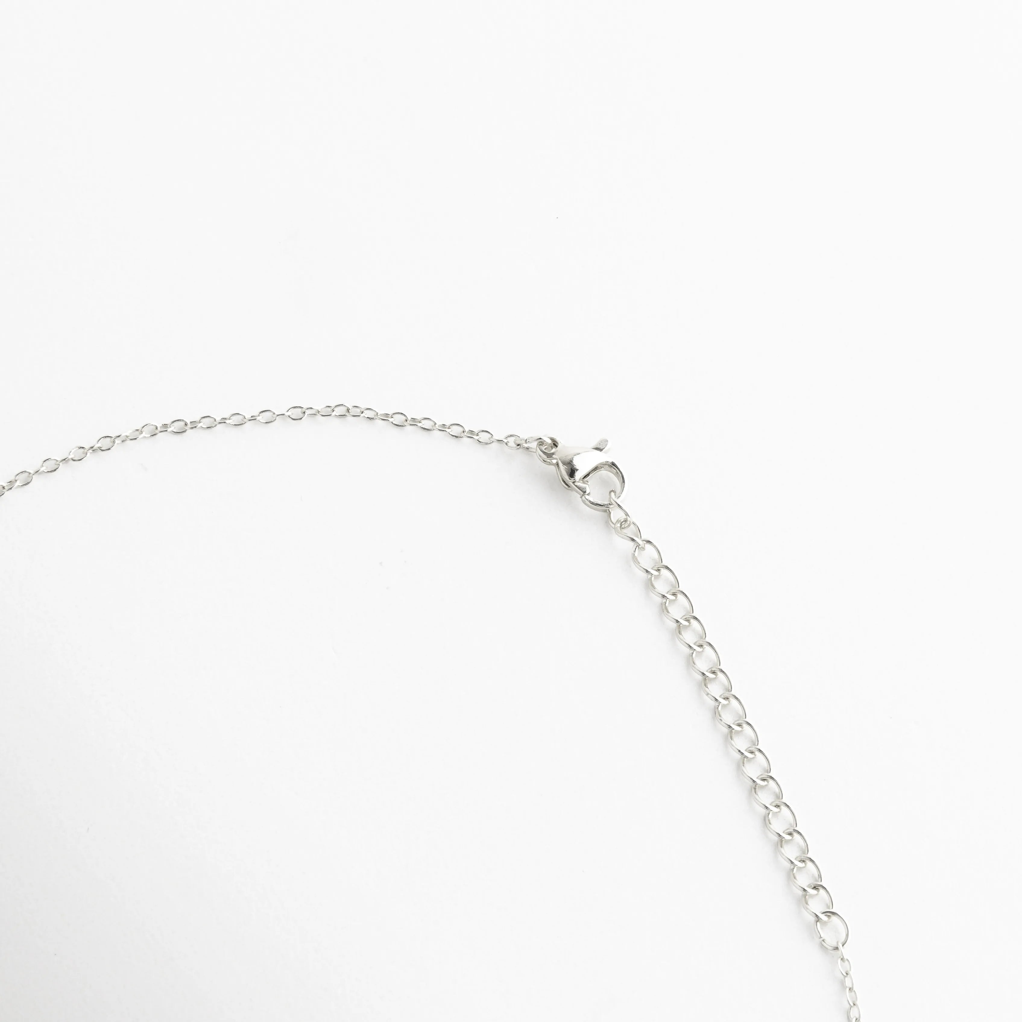 broche de collar plateado elegante, detalle de cadena fina plateada, collar de corazón con cierre seguro, joyería fina plateada pulida, collar plateado versátil y cómodo, collar elegante de alta calidad