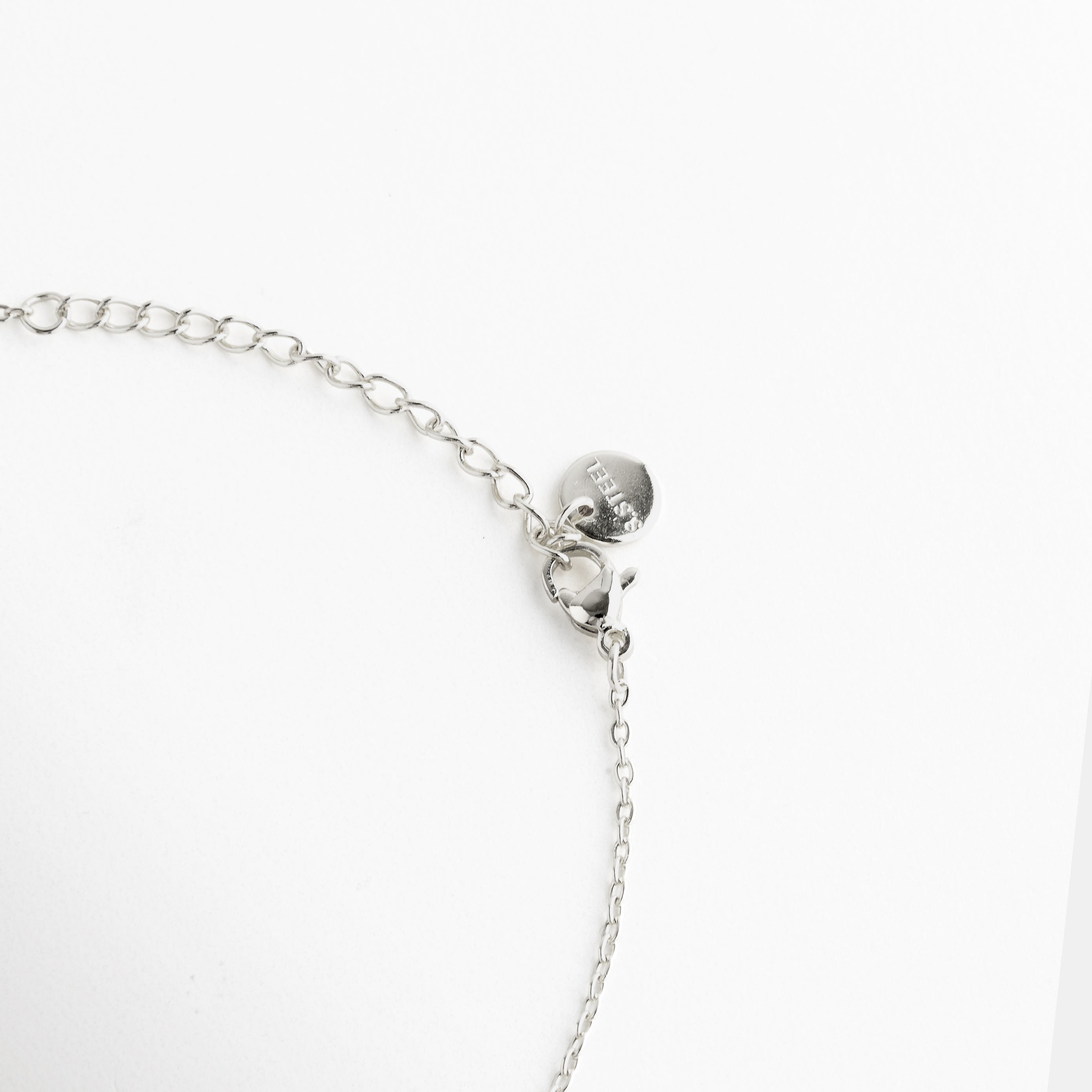 Cierre del collar con extensión ajustable, Broche tipo lobster del collar, Detalle del cierre y cadena posterior, Sistema de ajuste del collar fino, Terminación posterior del collar