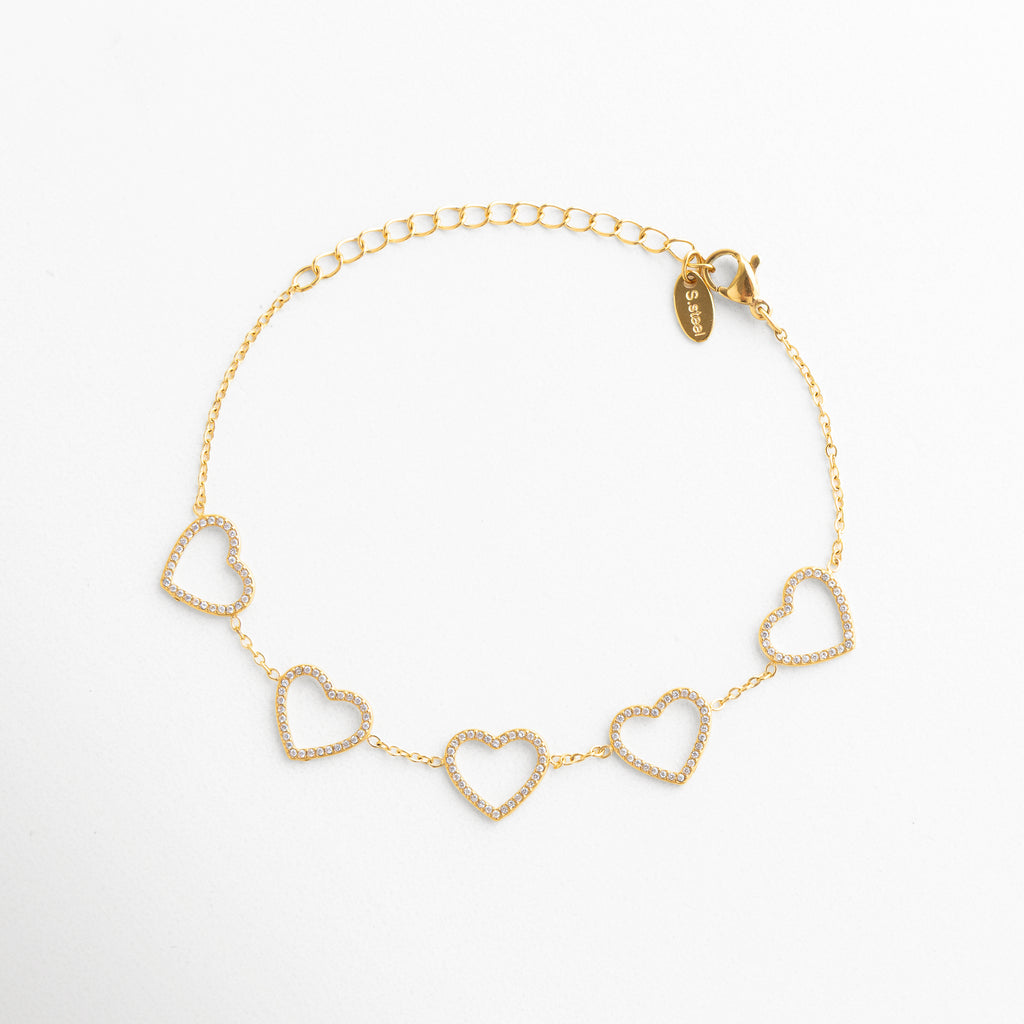 detalle de corazones en pulsera dorada, corazones dorados con acabado pulido, pulsera elegante con diseño romántico, joyería femenina con corazones delicados, pulsera dorada de estética sofisticada, detalle fino de pulsera de corazones