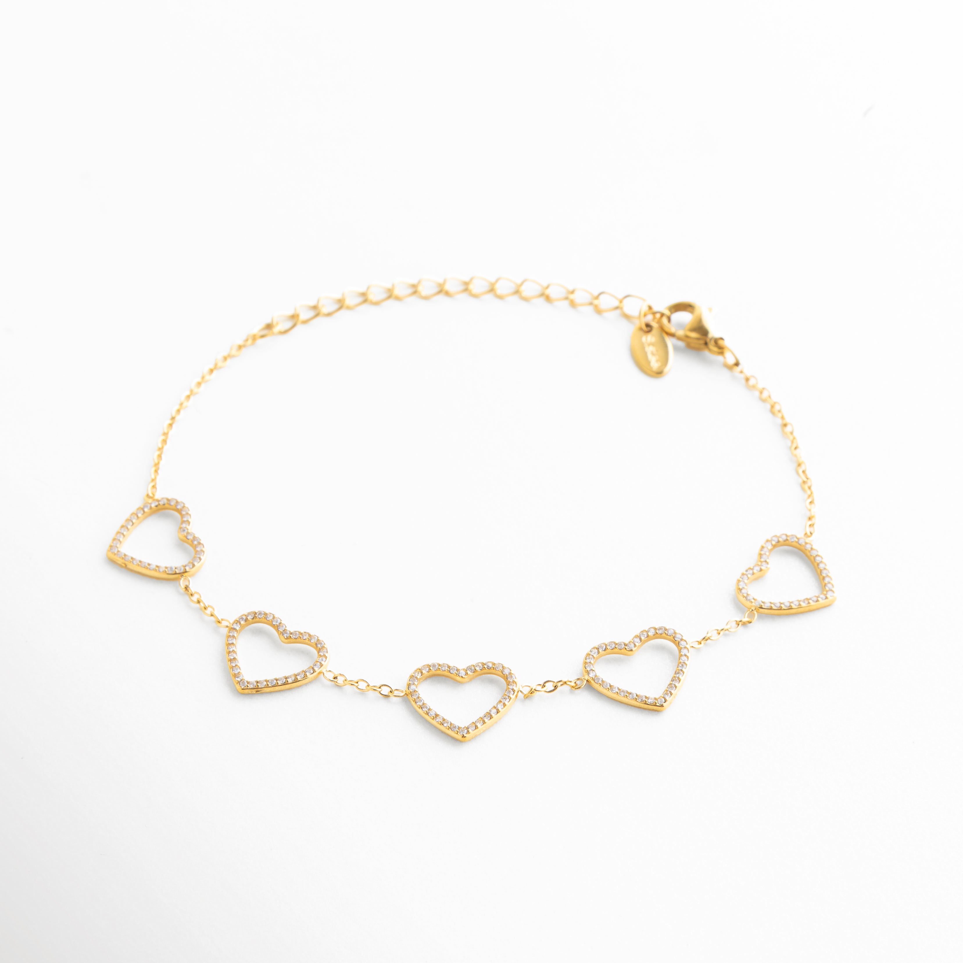 detalle de corazones en pulsera dorada, corazones dorados con acabado pulido, pulsera elegante con diseño romántico, joyería femenina con corazones delicados, pulsera dorada de estética sofisticada, detalle fino de pulsera de corazones