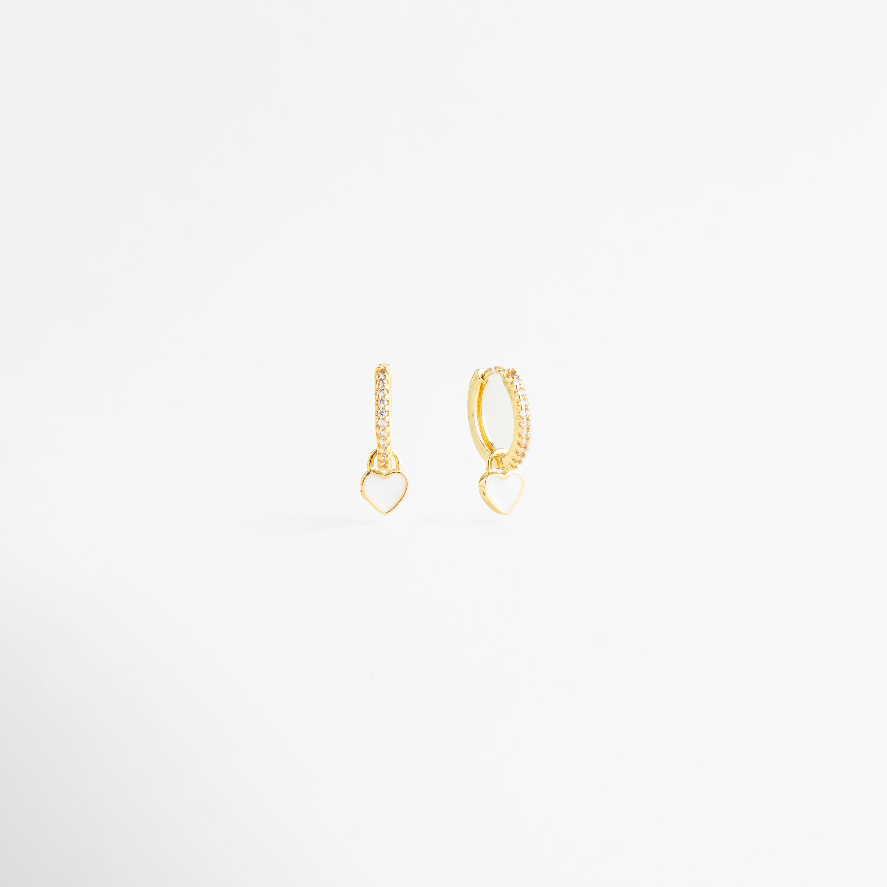 aretes dorados con corazón blanco esmaltado, aretes delicados de corazón blanco con zirconias, aretes finos colgantes con corazón blanco elegante, joyería femenina con corazón blanco y acabado brillante, aretes minimalistas de corazón blanco para uso diario, aretes elegantes con diseño alargado y corazón blanco