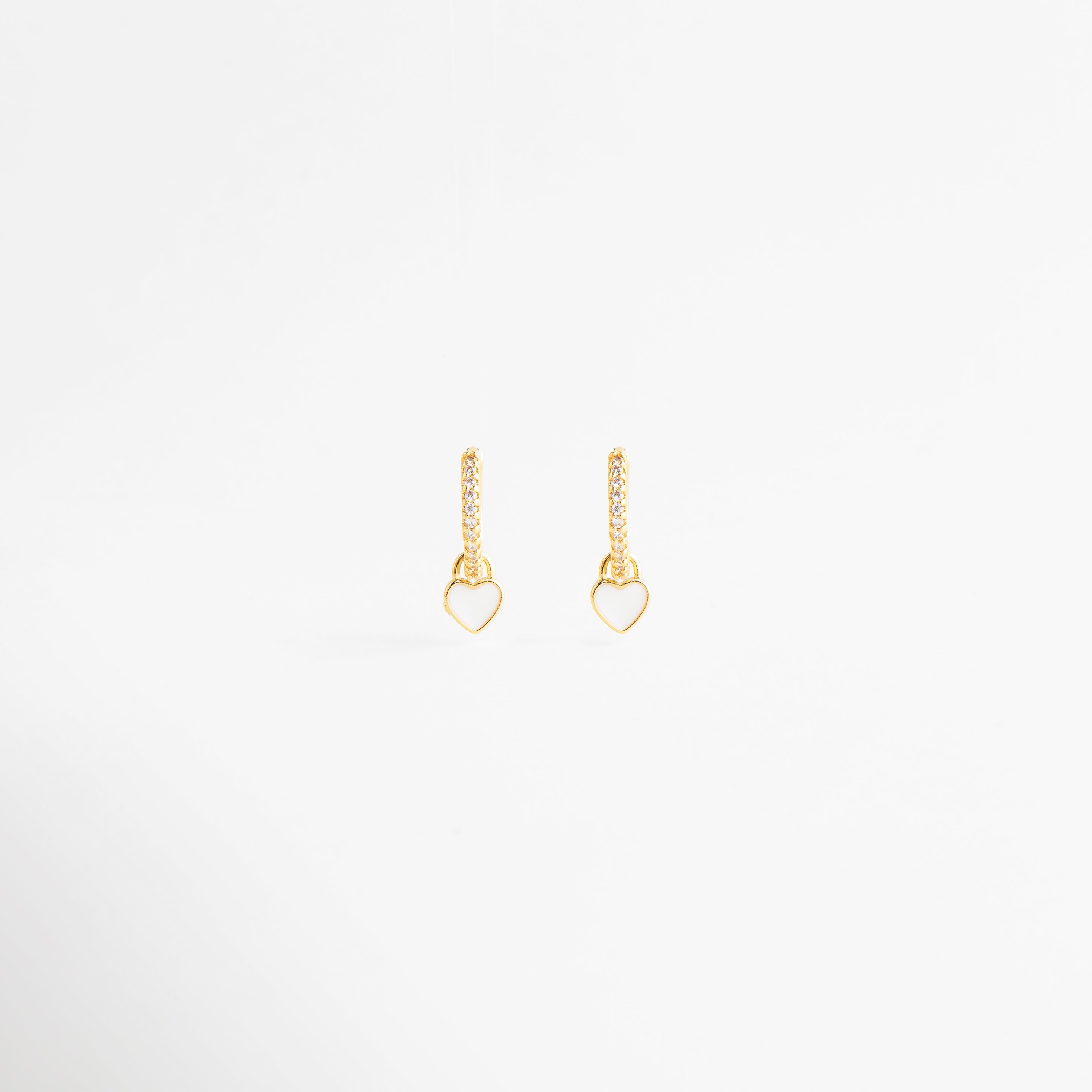 aretes dorados con corazón blanco esmaltado, aretes delicados de corazón blanco con zirconias, aretes finos colgantes con corazón blanco elegante, joyería femenina con corazón blanco y acabado brillante, aretes minimalistas de corazón blanco para uso diario, aretes elegantes con diseño alargado y corazón blanco