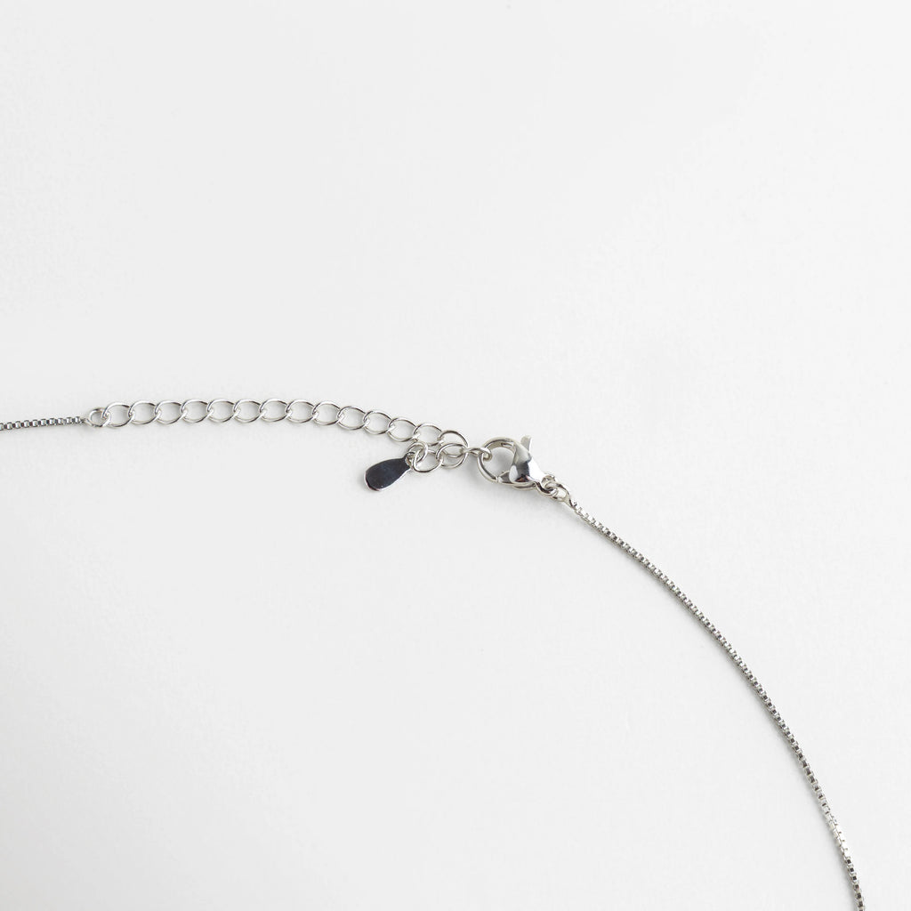 Detalle del cierre de langosta y cadena de extensión ajustable con acabado plateado, Vista de cerca del sistema de seguridad y eslabones de la cadena del collar, Broche ajustable de alta calidad para gargantilla con piedras turquesa, Detalle técnico del mecanismo de cierre y eslabones de extensión del set, Acercamiento al acabado pulido del broche del collar sobre fondo blanco.