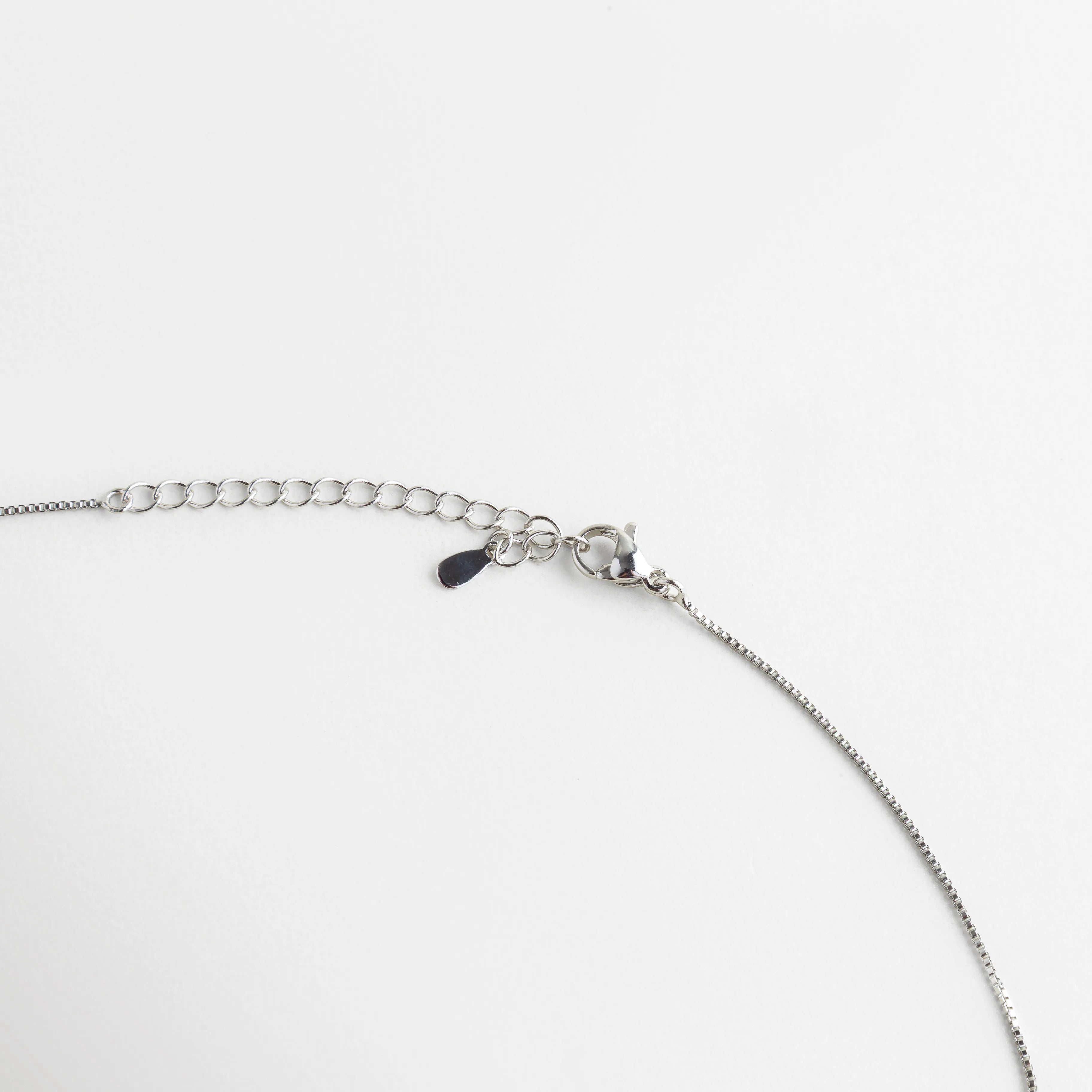Detalle del cierre de langosta y cadena de extensión ajustable con acabado plateado, Vista de cerca del sistema de seguridad y eslabones de la cadena del collar, Broche ajustable de alta calidad para gargantilla con piedras turquesa, Detalle técnico del mecanismo de cierre y eslabones de extensión del set, Acercamiento al acabado pulido del broche del collar sobre fondo blanco.