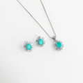 Set de collar y aretes con piedras ovaladas color turquesa neón y halo de cristales, Conjunto de joyería fina con gemas de imitación Paraiba en acabado plateado brillante, Gargantilla y aretes a juego con piedras centrales azul turquesa y marco de zirconias, Set de joyería de lujo con piedras ovaladas vibrantes sobre fondo blanco minimalista, Juego de collar con dije ovalado y pendientes tipo broquel con brillo tipo diamante.