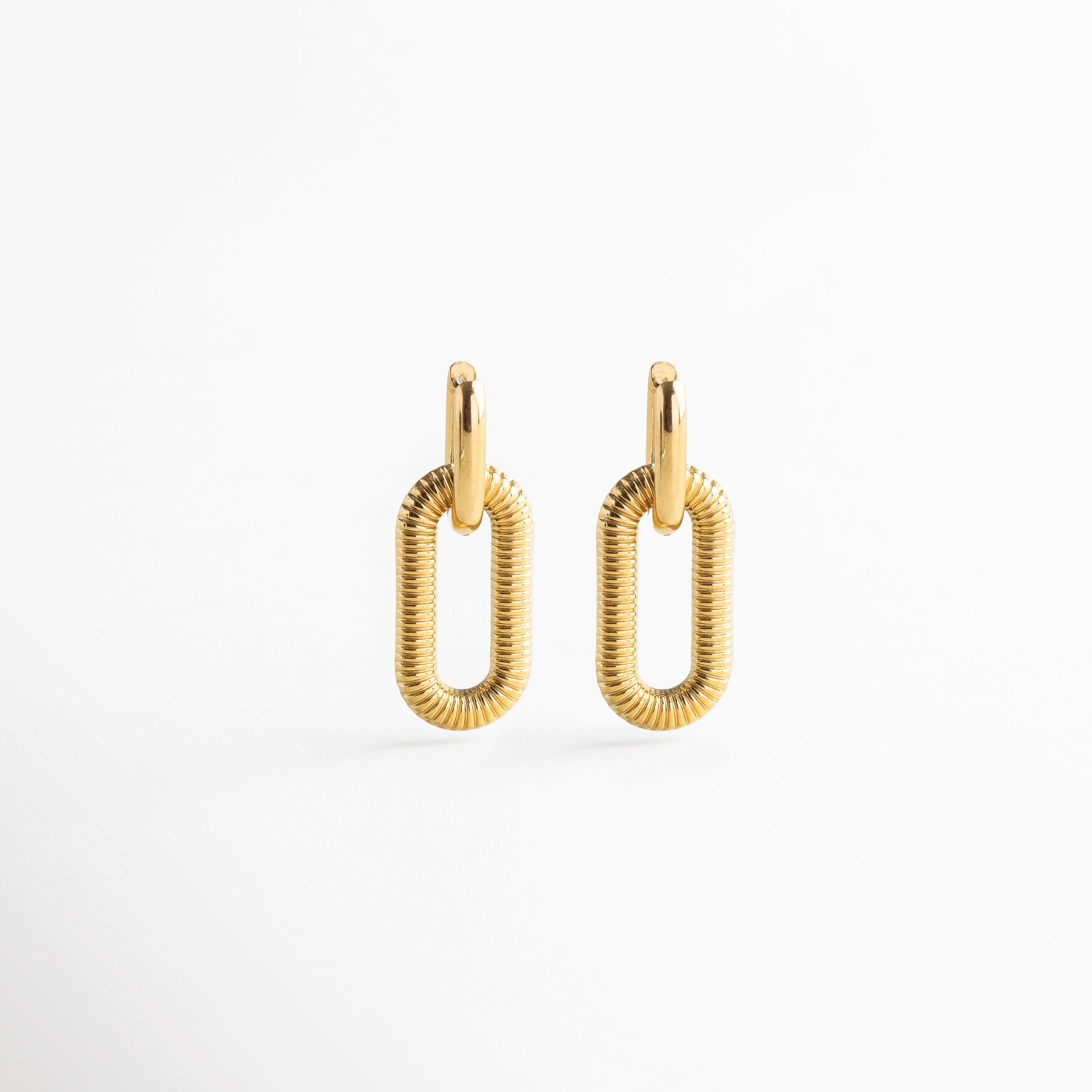 Aretes dorados con textura vistos en ángulo, Perfil del clip desmontable dorado con acabado texturizado, Diseño angular de arete desmontable con textura, Vista lateral del pendiente con efecto desmontable