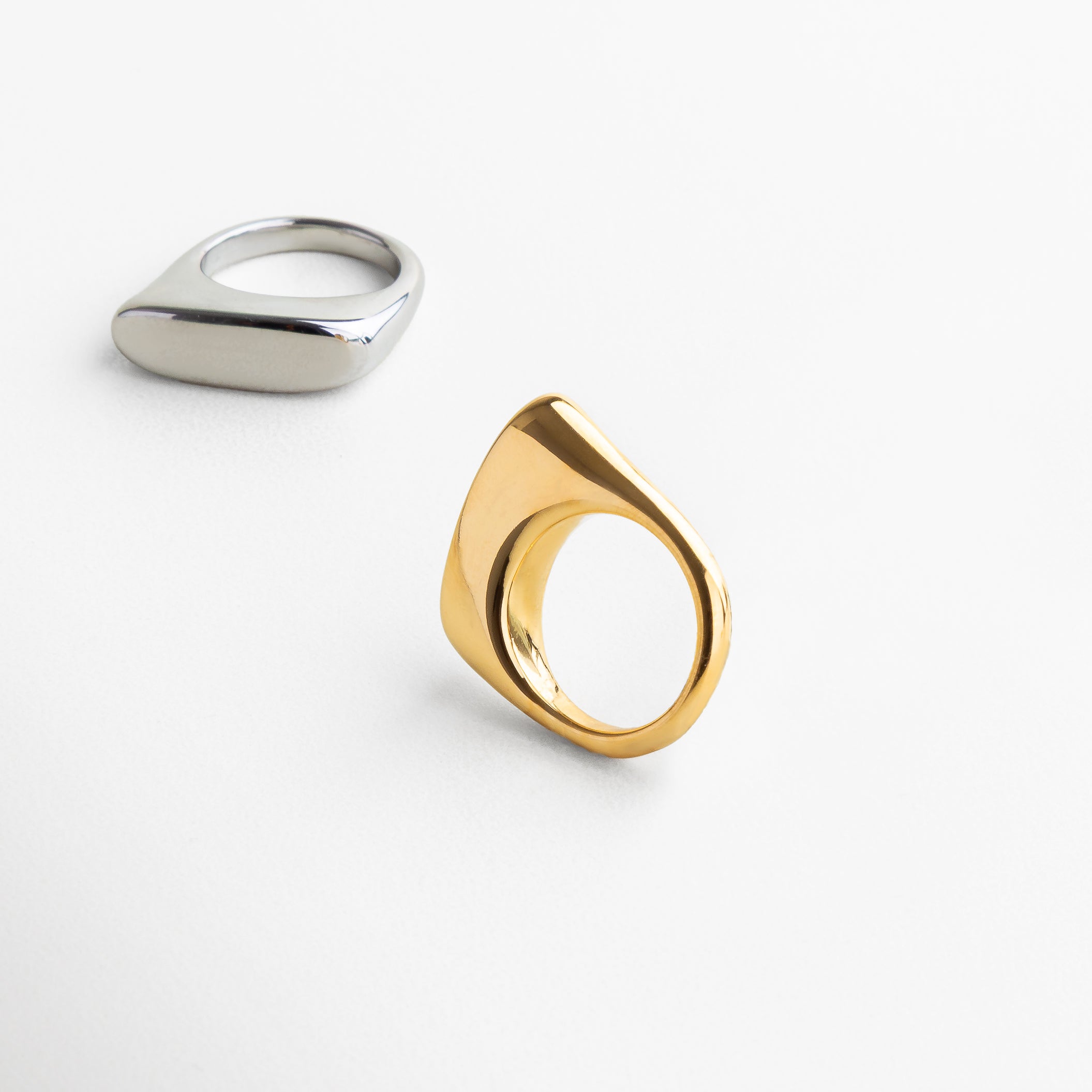 Anillo Génova Dorado visto de perfil, con diseño asimétrico y curvaturas suaves en acabado oro de 18K. Vista lateral del anillo artístico Génova, con forma innovadora y elegante acabado metálico dorado. Lado del anillo Génova, mostrando su diseño moderno y estructura bold en acero con baño de oro. Detalle lateral del anillo dorado Génova, ideal para un look sofisticado y diferente.
Perfil del anillo Génova Dorado, con silueta única y diseño que rompe con lo tradicional.