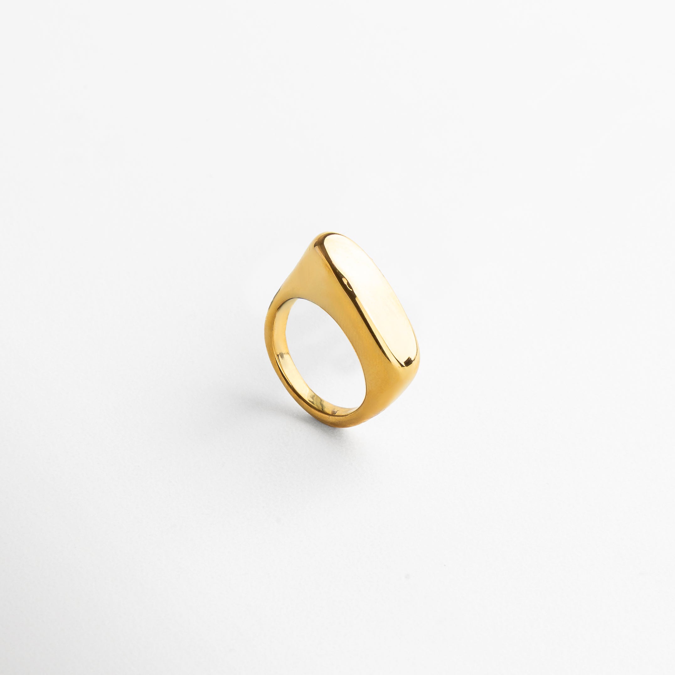 Vista superior del anillo Génova Dorado, mostrando su forma asimétrica y superficie pulida en oro 18K. Anillo Génova en dorado visto desde arriba, con diseño escultórico y elegante. Toma cenital del anillo moderno Génova, resaltando su estructura artística en dorado brillante. Anillo dorado Génova desde vista superior, ideal como pieza protagonista de un look contemporáneo.
Perspectiva superior del anillo Génova, con diseño abstracto y acabado en acero inoxidable dorado.