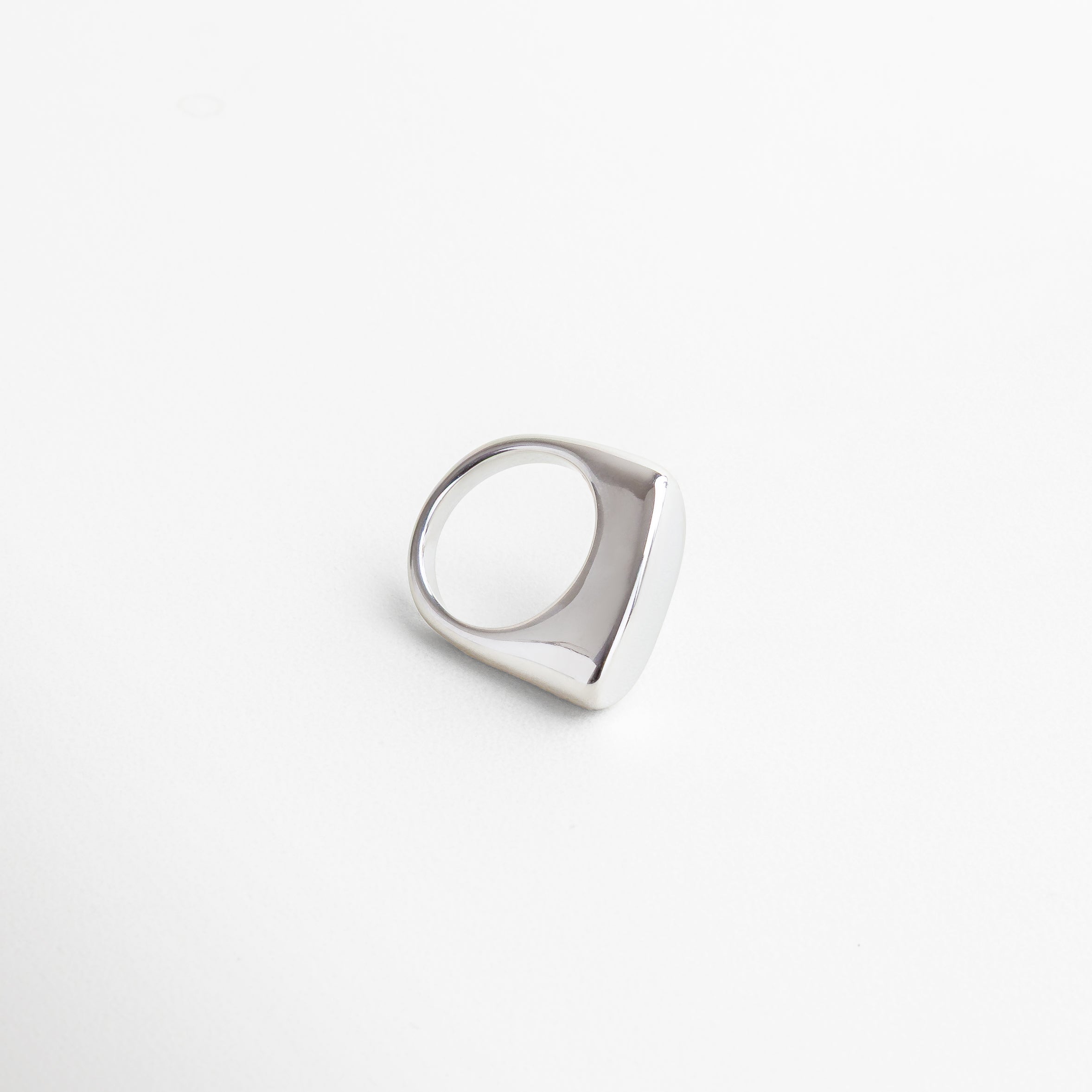 Vista superior del anillo Génova Plateado, mostrando su estructura asimétrica y acabado pulido.Anillo moderno Génova visto desde arriba, con diseño abstracto en acero inoxidable brillante. Toma cenital del anillo Génova Plateado, con forma única y estilo minimalista con carácter. Perspectiva superior del anillo en tono plateado, ideal para destacar en combinaciones creativas. Vista desde arriba del anillo Génova, con acabado metálico frío y diseño escultural