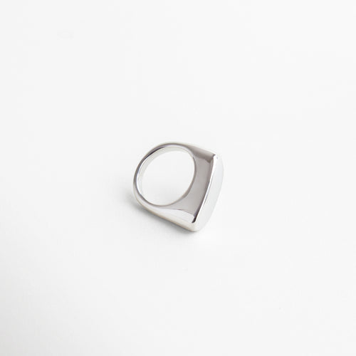 Vista superior del anillo Génova Plateado, mostrando su estructura asimétrica y acabado pulido.Anillo moderno Génova visto desde arriba, con diseño abstracto en acero inoxidable brillante. Toma cenital del anillo Génova Plateado, con forma única y estilo minimalista con carácter. Perspectiva superior del anillo en tono plateado, ideal para destacar en combinaciones creativas. Vista desde arriba del anillo Génova, con acabado metálico frío y diseño escultural
