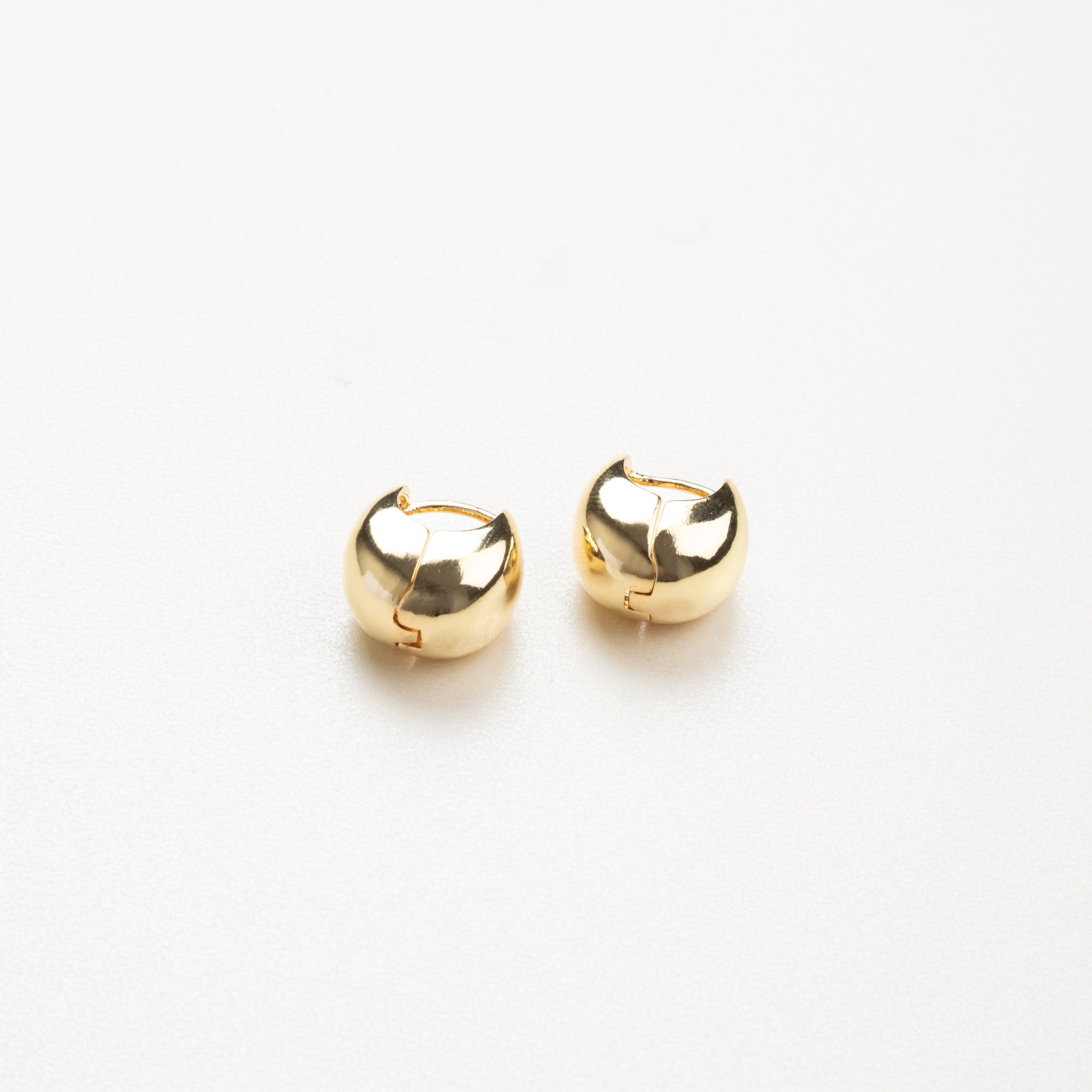 Vista frontal de aretes dorados sencillos, diseño limpio y atemporal.