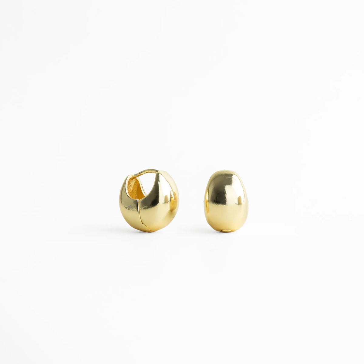 Vista frontal de aretes dorados pequeños con forma esférica y brillo espejo, diseño clásico y atemporal para cualquier ocasión.