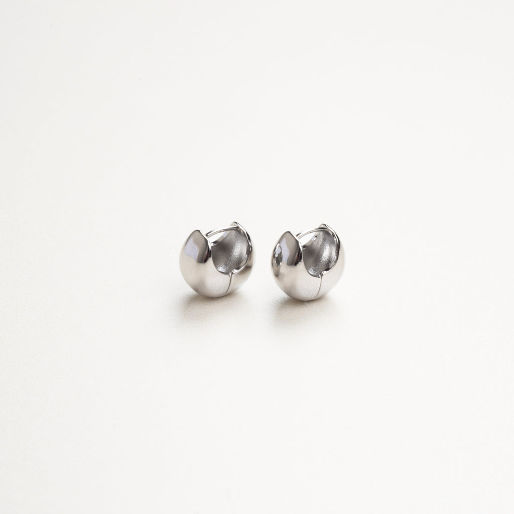 Vista frontal de aretes plateados sencillos, diseño limpio y minimalista