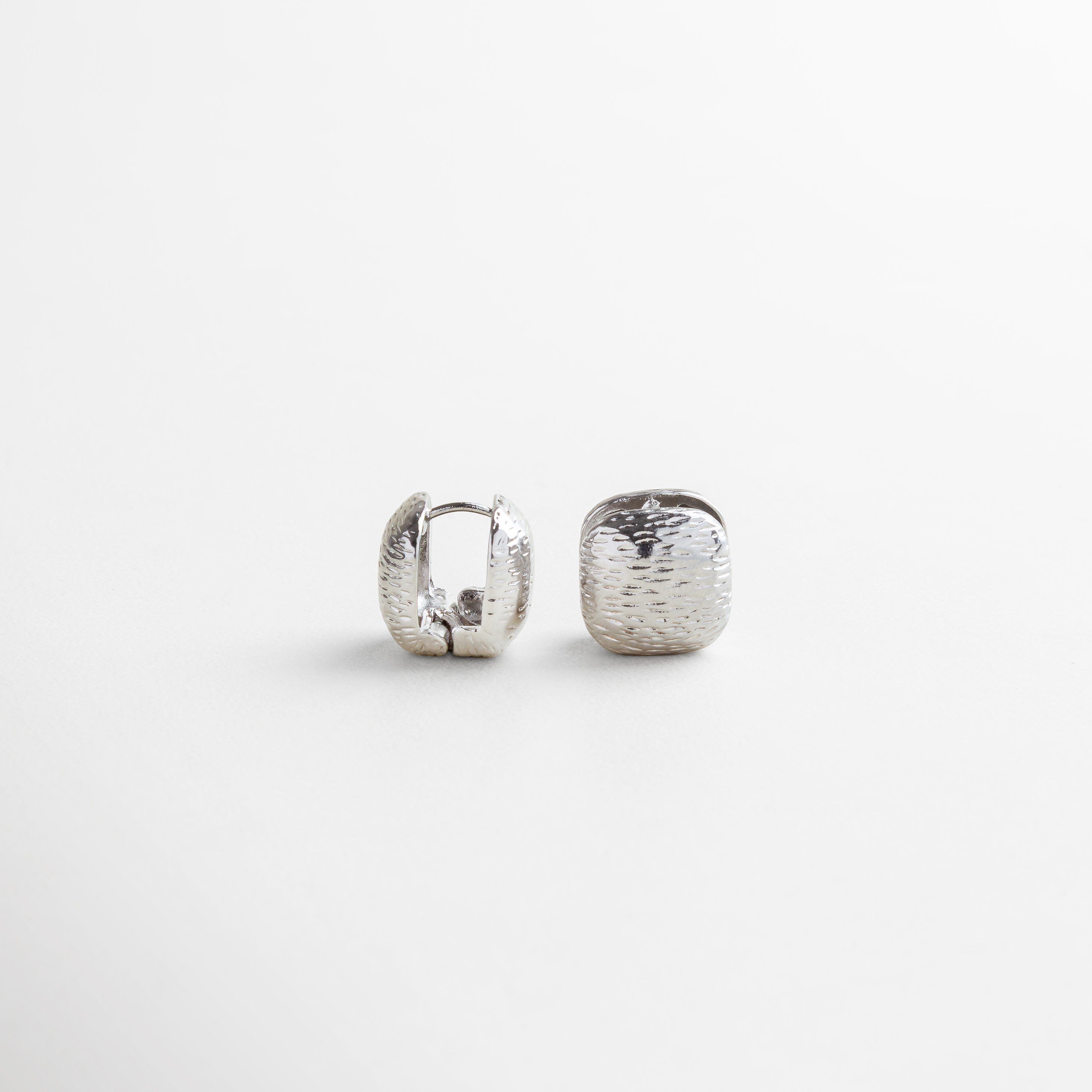 Vista superior del Anillo Idriss plateado, con diseño de 2.5 cm lleno de brillo gracias a sus zirconias incrustadas. Toma cenital del anillo en acabado plateado, con detalles que evocan elegancia clásica y moderna. Anillo de plata 925 con zirconias visto desde arriba, mostrando su forma estilizada y brillante. Perspectiva superior del Anillo Idriss plateado, con distribución armoniosa de las piedras brillantes. Vista desde arriba del anillo plateado, con forma alargada y acabado reluciente.
