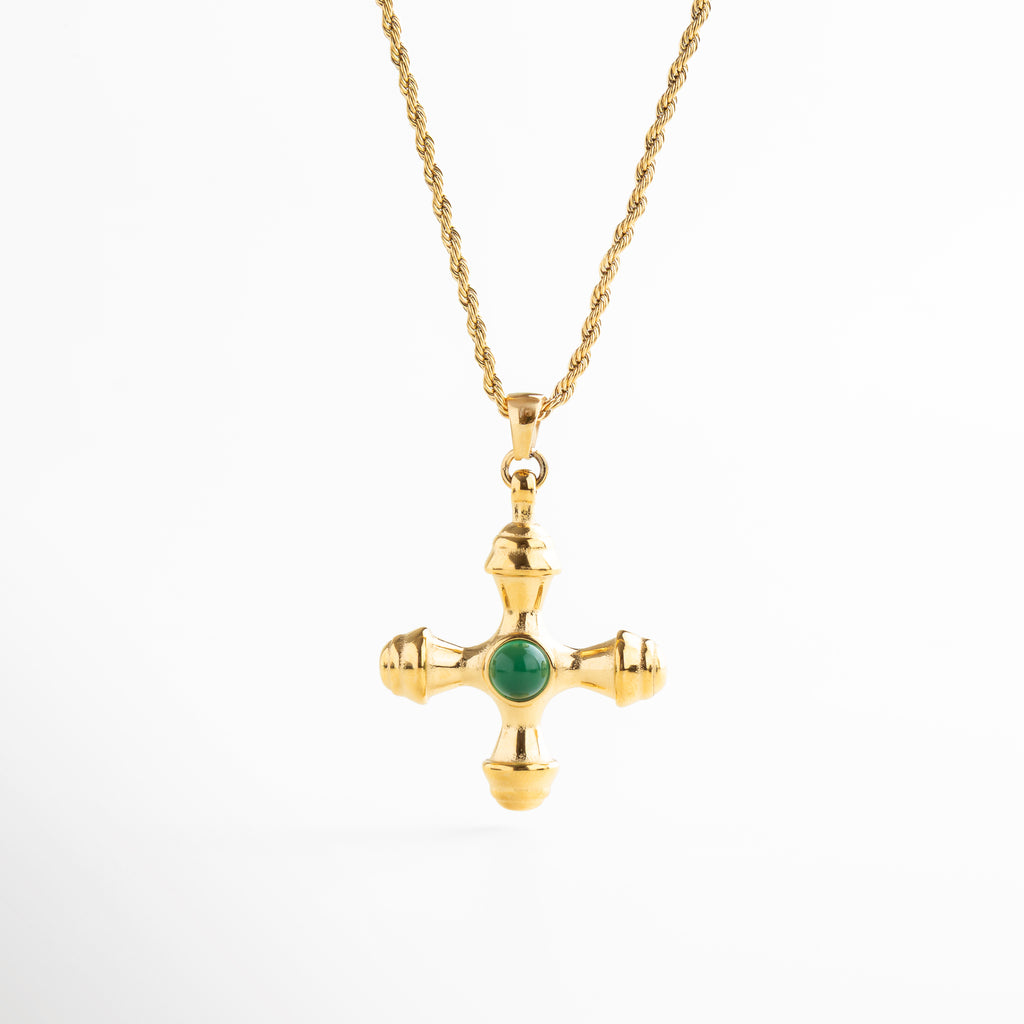 Collar dorado con dije de cruz desestructurada y piedra verde, Collar con cruz irregular y centro de piedra verde sintética, Joya dorada con cruz moderna y detalle vibrante, Collar chapado en oro con dije en forma de cruz contemporánea