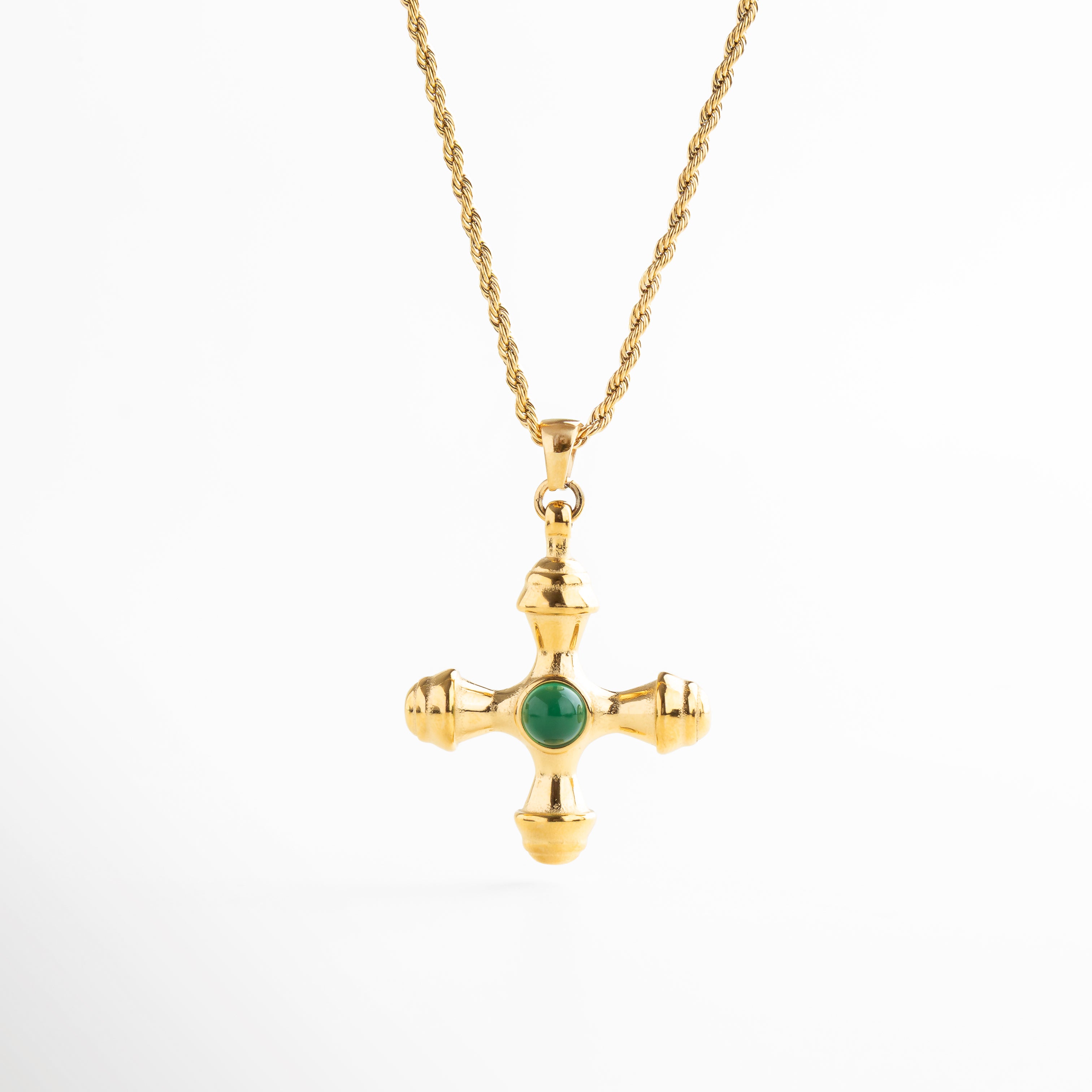 Collar dorado con dije de cruz desestructurada y piedra verde, Collar con cruz irregular y centro de piedra verde sintética, Joya dorada con cruz moderna y detalle vibrante, Collar chapado en oro con dije en forma de cruz contemporánea