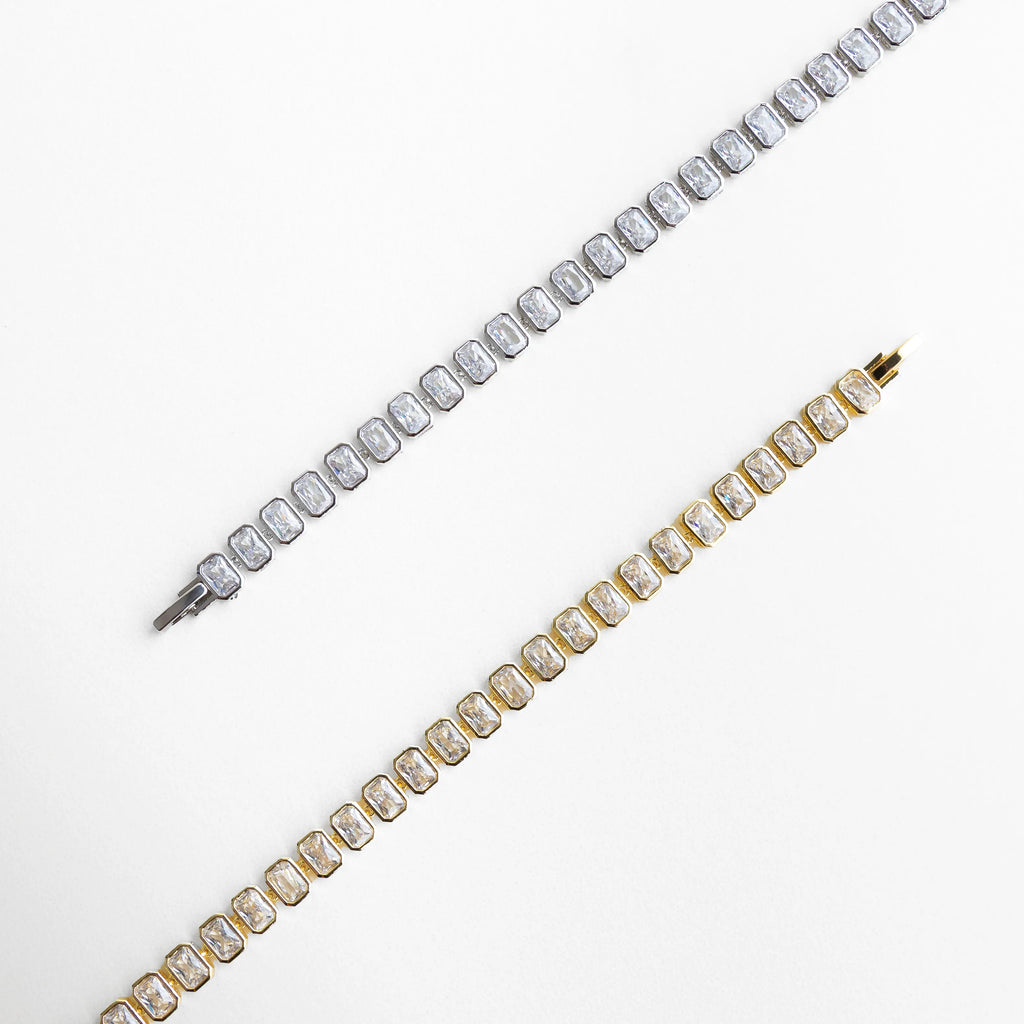 Collar Jung Golden en versiones dorado y plateado con zirconias cúbicas brillantes, Comparativa de collar tipo tenis en acabado oro 18K y tono plateado elegante, Dos variantes de collar con zirconias cuadradas en estilos dorado y plata, Collar elegante disponible en dorado y plateado con brillo sofisticado, Opciones de collar con zirconias cúbicas en acabados modernos y versátiles