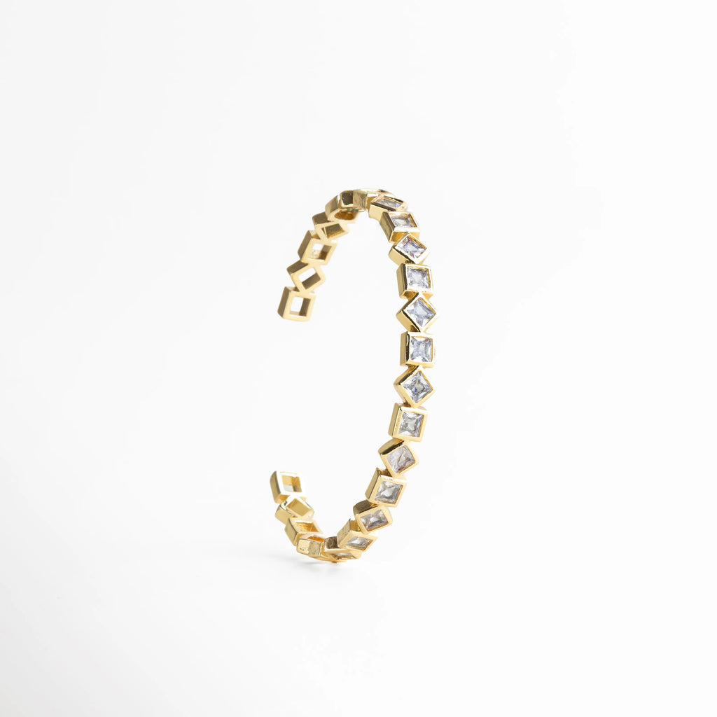 pulsera dorada vista lateral, detalle pulsera geométrica, joyería dorada moderna, pulsera con diseño arquitectónico, accesorios sofisticados mujer, pulsera femenina refinada, joyería contemporánea, pulsera de diseño