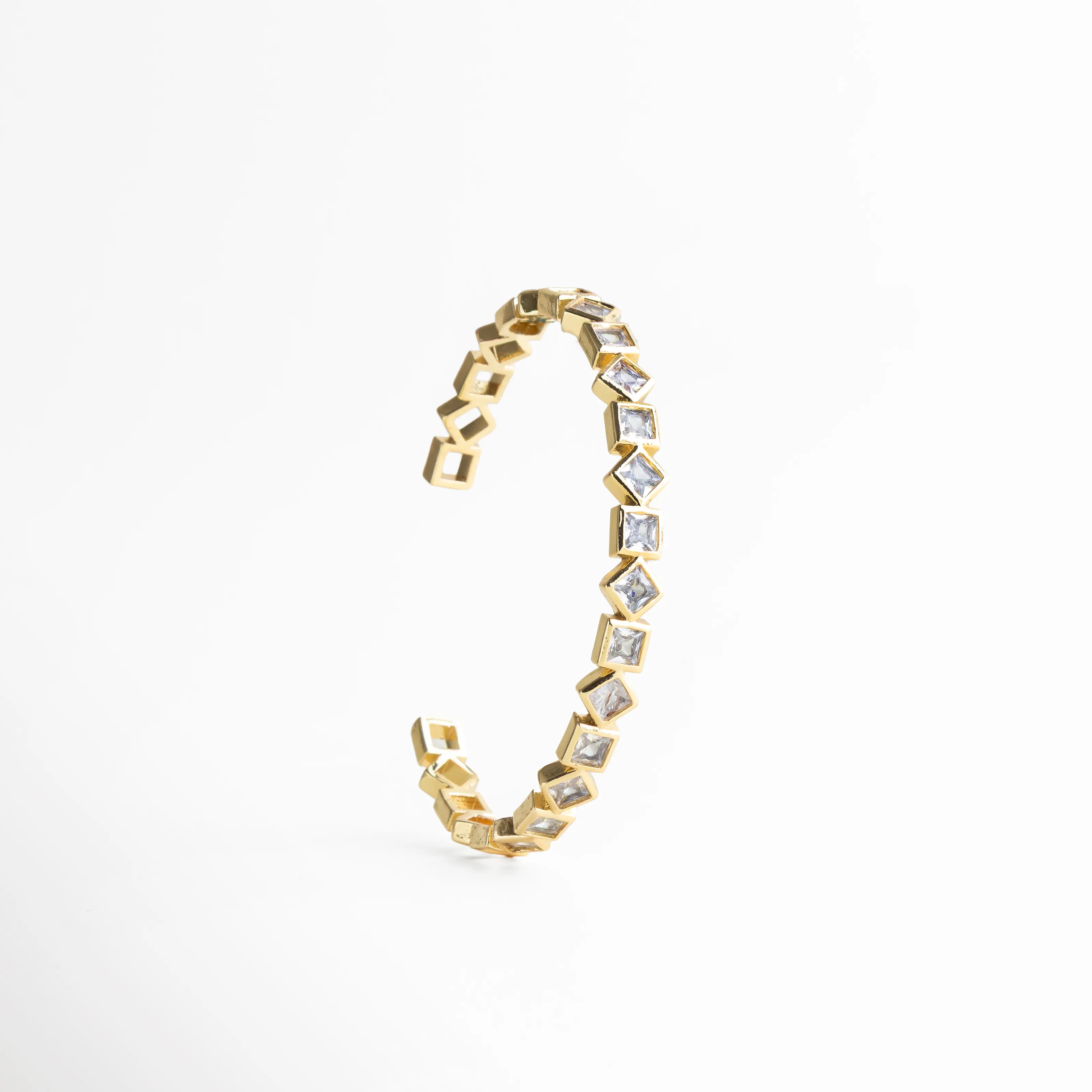 pulsera dorada vista lateral, detalle pulsera geométrica, joyería dorada moderna, pulsera con diseño arquitectónico, accesorios sofisticados mujer, pulsera femenina refinada, joyería contemporánea, pulsera de diseño