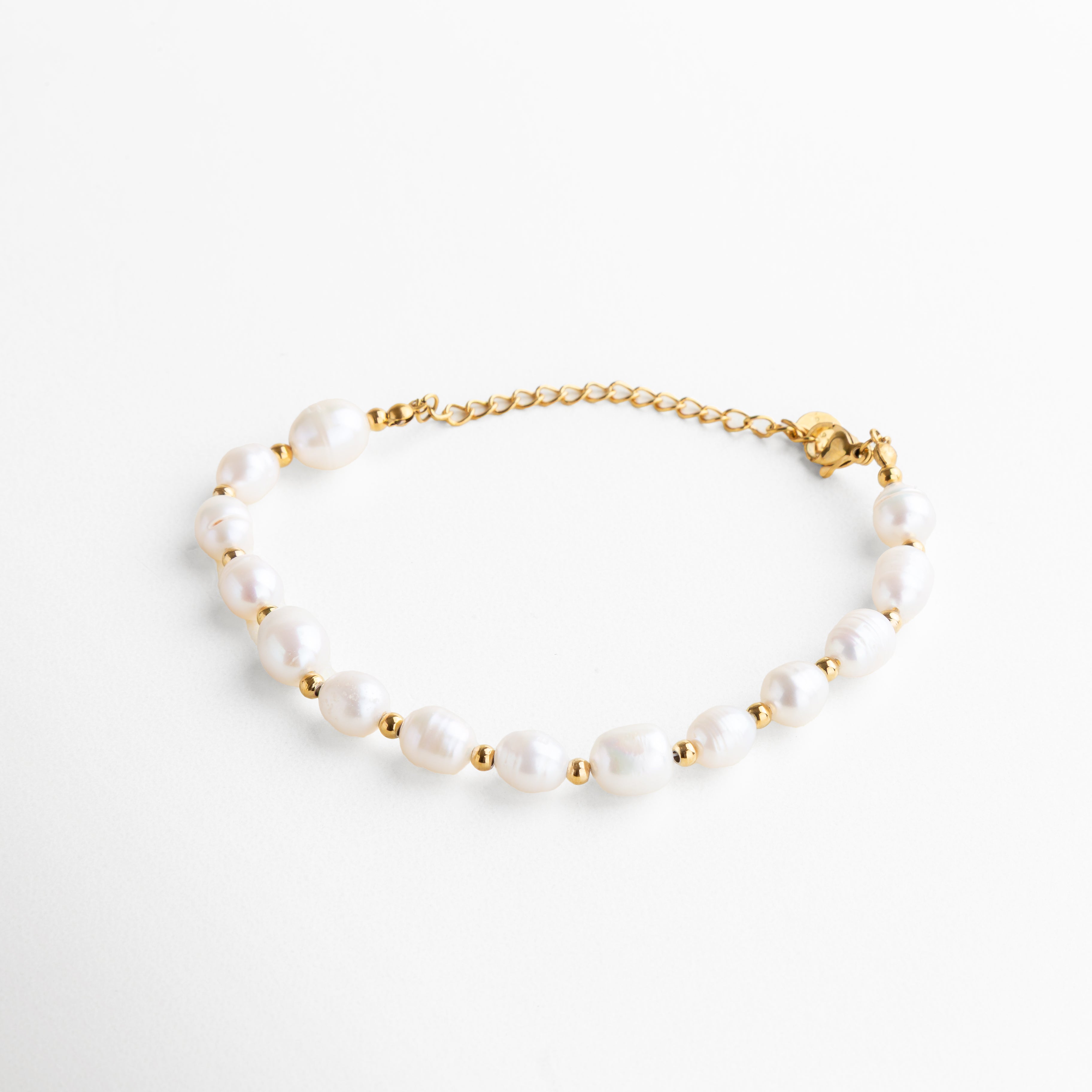 pulsera dorada con perlas de agua de imitación, diseño elegante y atemporal, acabado en oro 18K, joya femenina y sofisticada, pieza ideal para combinar con otros accesorios