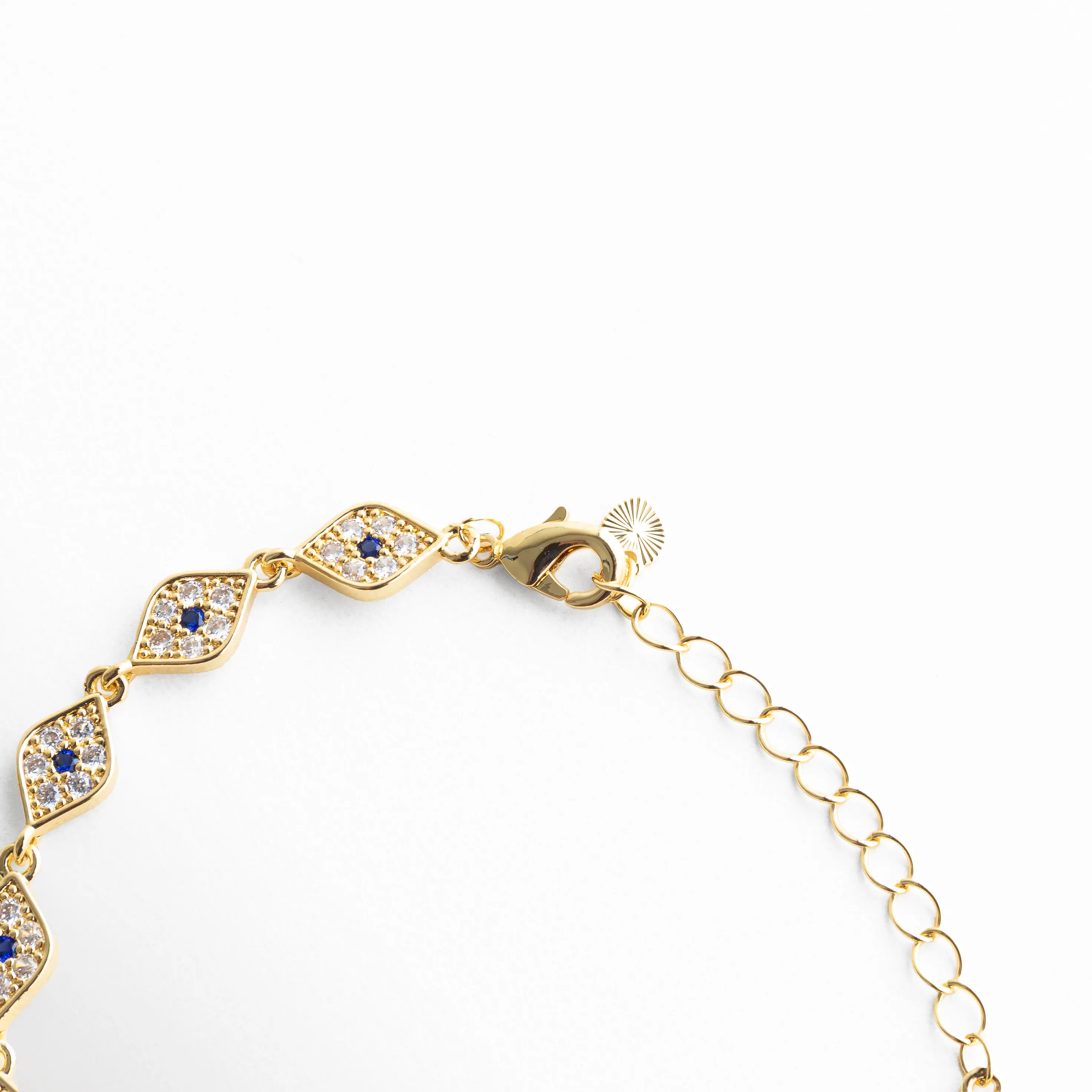 Cadena ajustable de pulsera dorada con pequeños ojos turcos y acabado en oro 18K, Detalle de cierre y extensión de pulsera con diseño delicado y zirconias, Vista de la estructura de la pulsera con eslabones finos y detalles brillantes, Pulsera de diseño continuo con ojos turcos y cadena dorada elegante, Segmento de pulsera con patrón repetido de ojo turco y brillo sutil