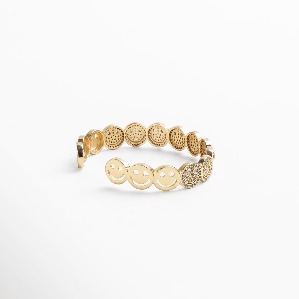 detalle de caritas sonrientes con zirconias en dorado, primeros planos de las caritas brillantes incrustadas, acabado texturizado de las caritas en la pulsera dorada, zirconias cúbicas sobre diseño de caritas en pulsera, caritas con brillo sutil sobre base enchapada en oro 