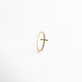 Anillo dorado ajustable con cruz al frente, bañado en Oro 18K e incrustado con zirconias negras, resaltando su brillo elegante.