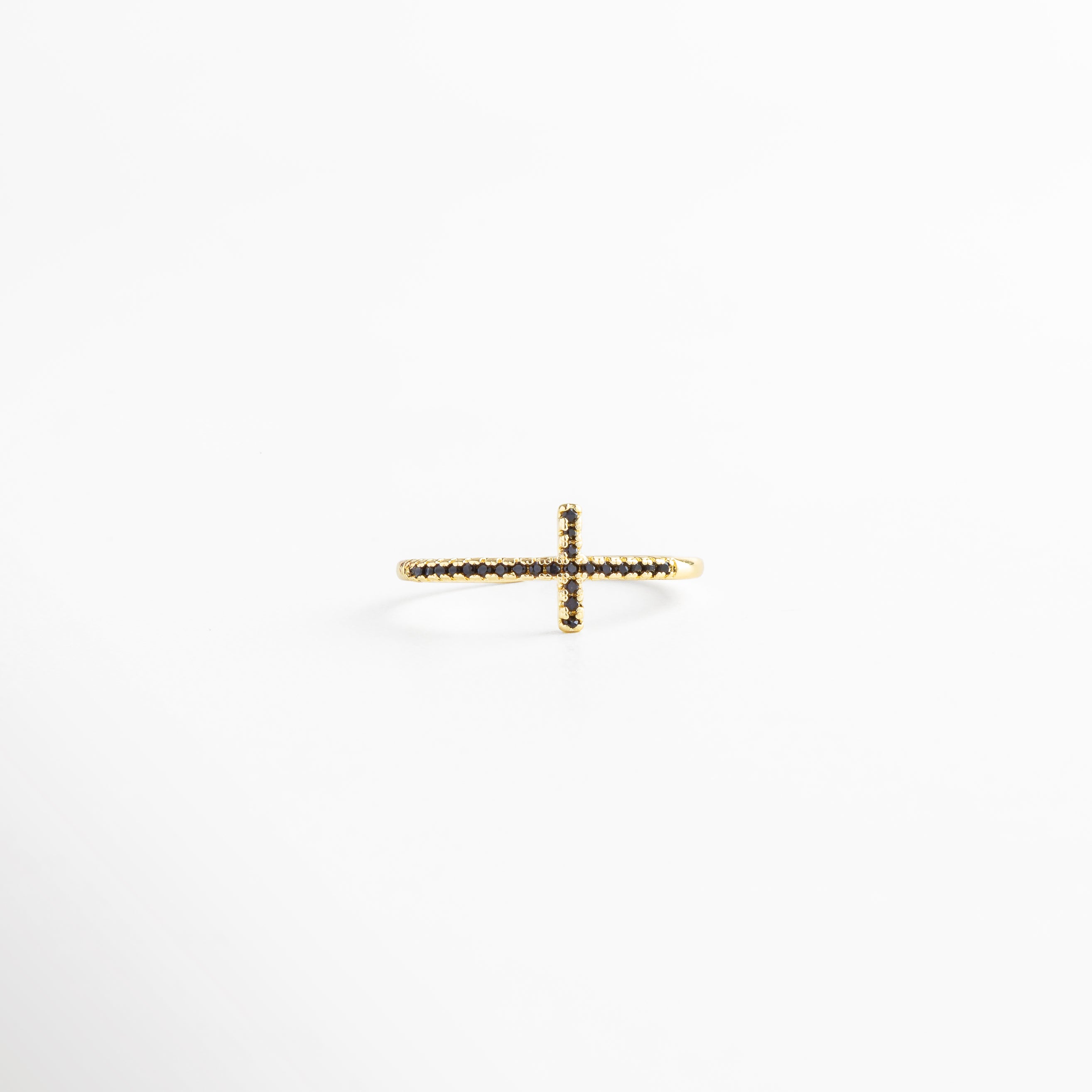 Anillo dorado ajustable visto desde arriba, con acabado en Oro 18K y cruz central de zirconias negras, mostrando su estructura abierta.