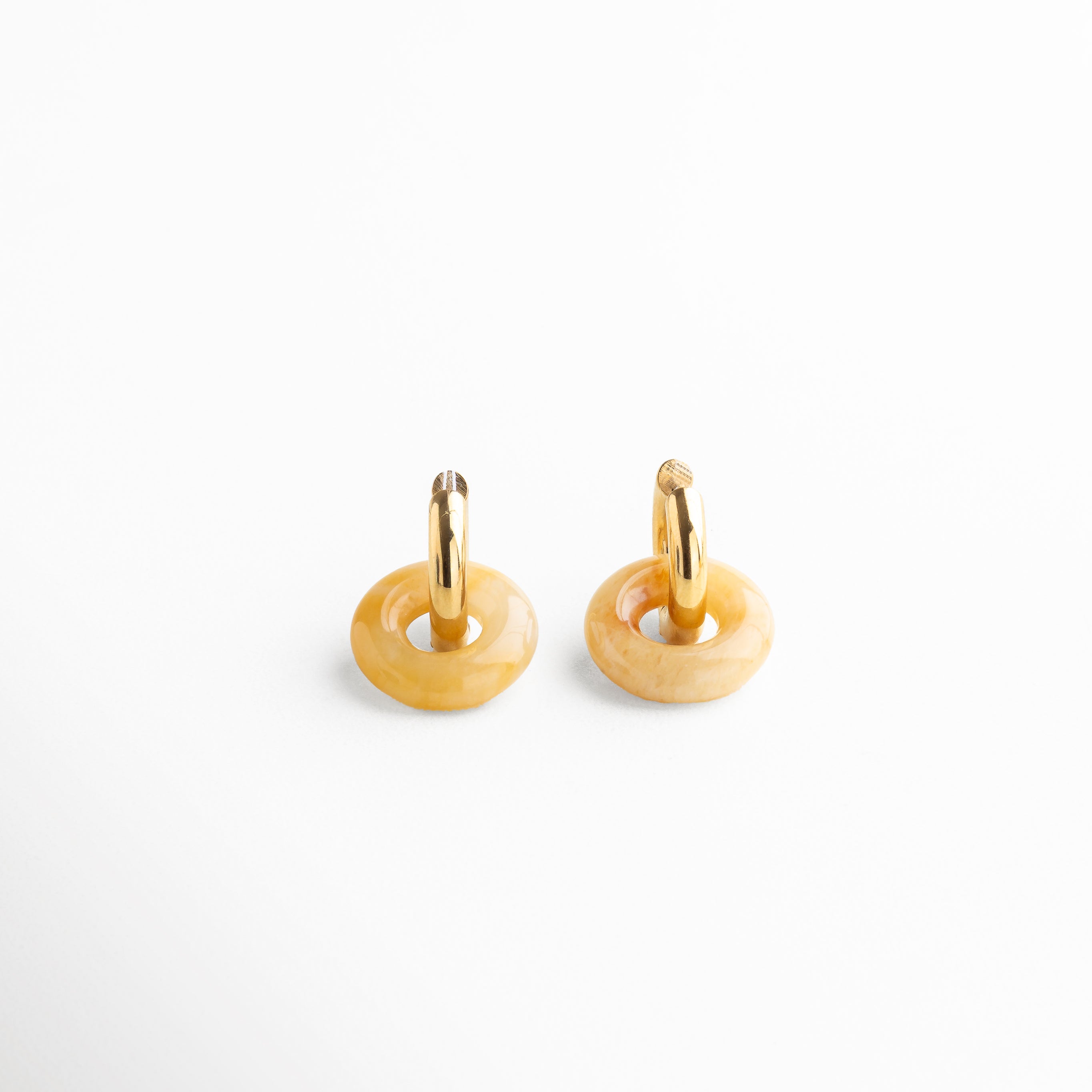 Primer plano de aro con aventurina naranja de imitación incrustada, Detalle del baño dorado y textura de los aretes Emilia Hoops, Incrustación naranja en aro dorado con acabado pulido, Detalle de piedra semipreciosa naranja en aro vintage
