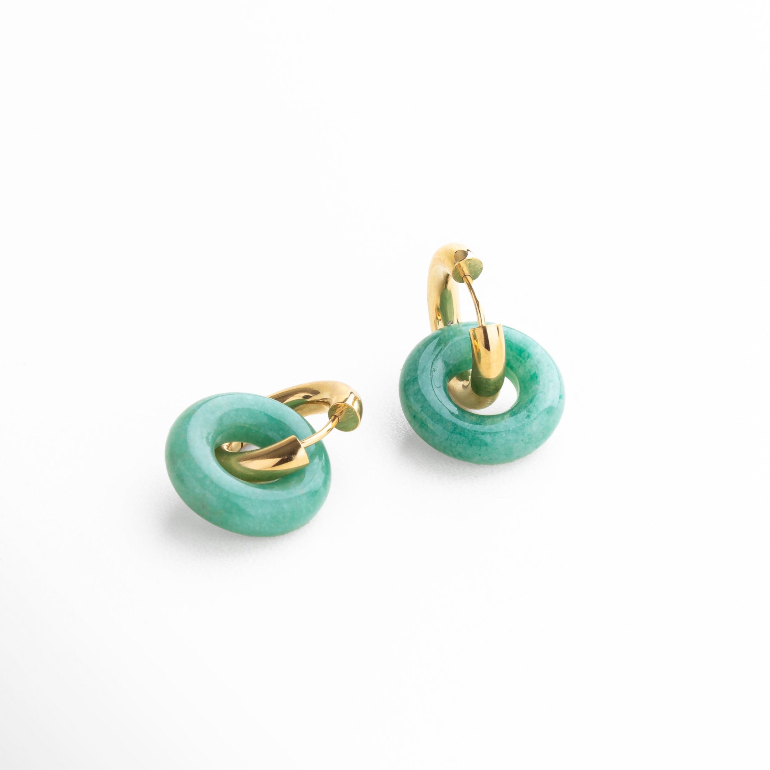 Primer plano de aro con piedra jade de imitación incrustada, Detalle del baño dorado y textura de los aretes Emilia Hoops con piedra jade, Incrustación verde jade en aro dorado con acabado pulido, Detalle de piedra semipreciosa jade en aro vintage