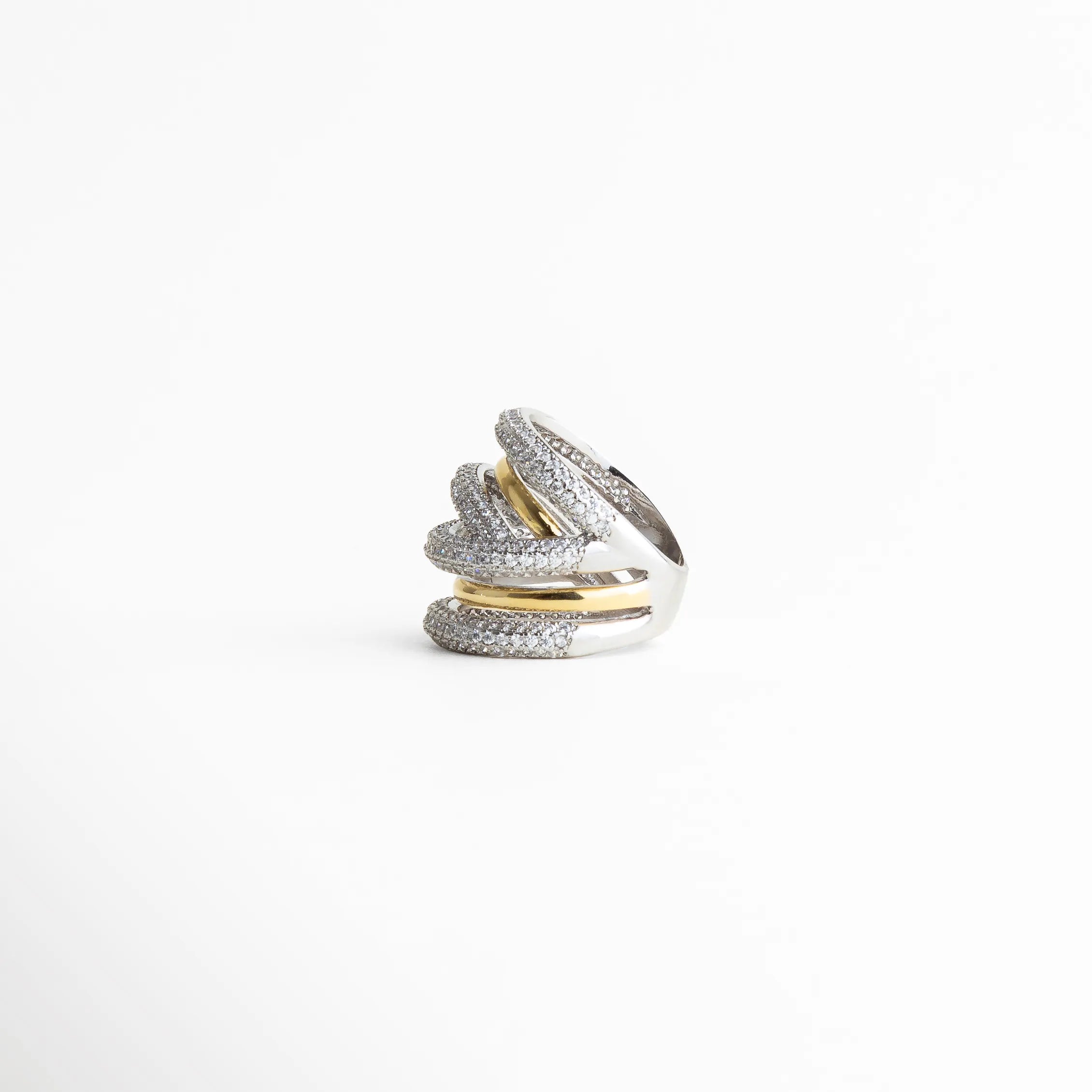 Vista frontal del anillo multibanda con brillo sutil, diseño envolvente y acabado refinado para joyería femenina.