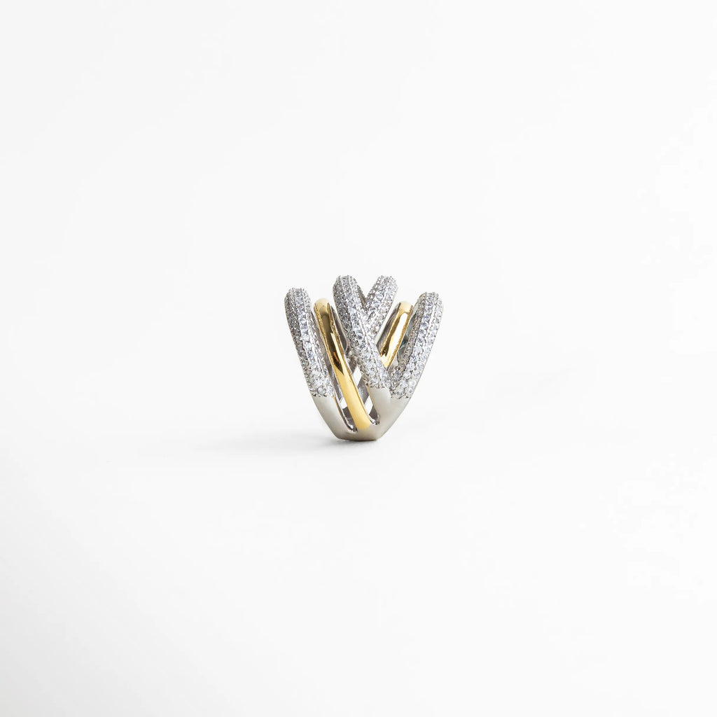 Detalle del diseño multibanda del anillo elegante con textura brillante y contraste de tonos metálicos.