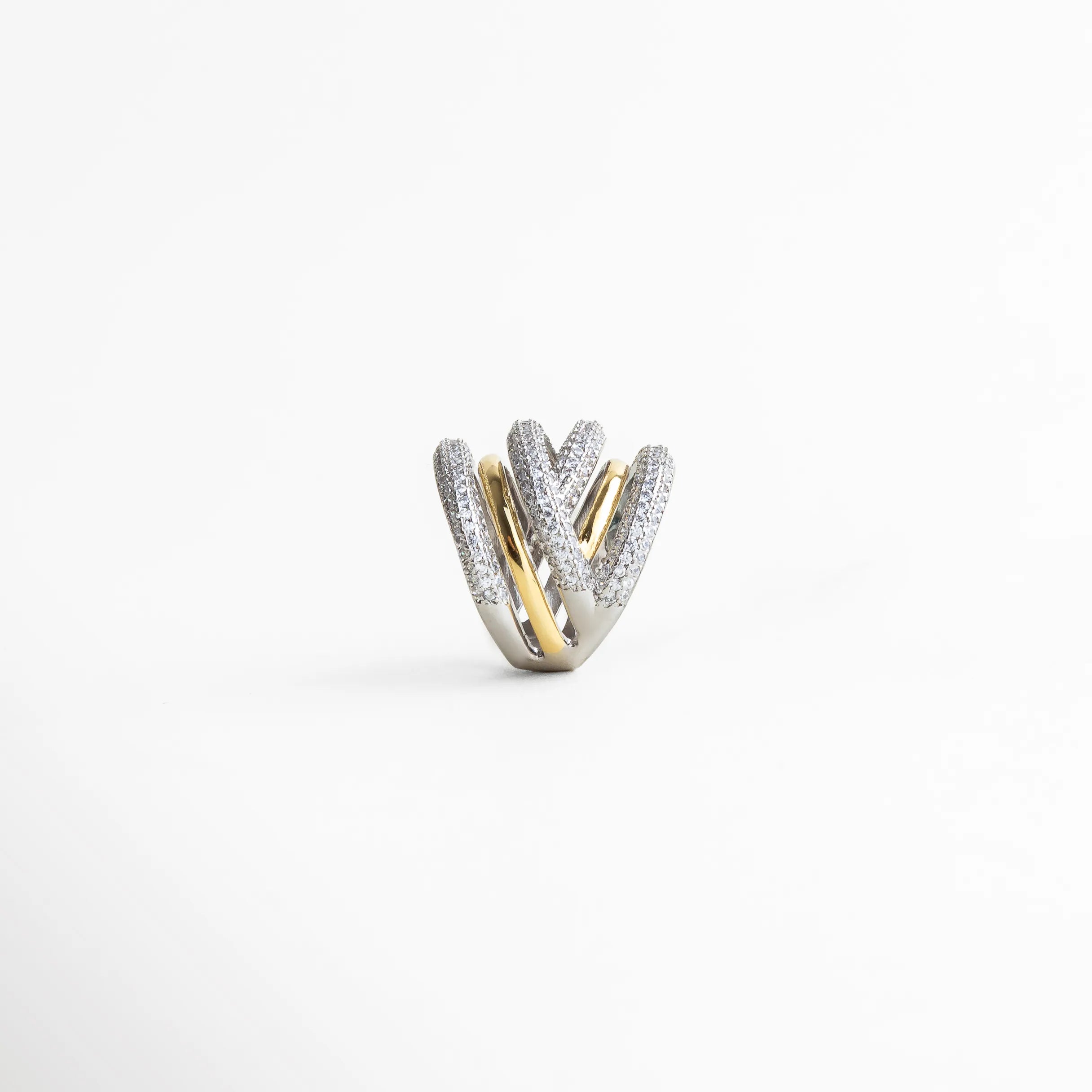 Detalle del diseño multibanda del anillo elegante con textura brillante y contraste de tonos metálicos.