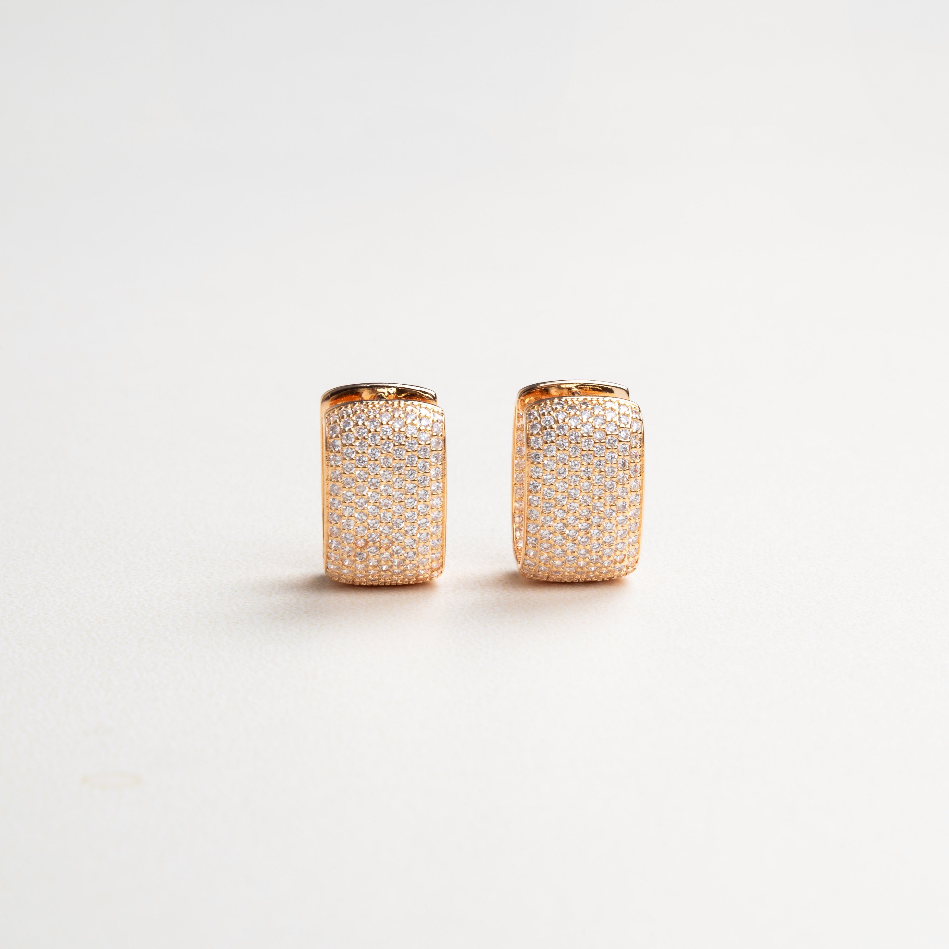 Elegantes aretes con zirconias medianamente grandes, brillando intensamente en un diseño sofisticado, ideal para ocasiones especiales y para dar un toque de lujo y estilo a cualquier look.