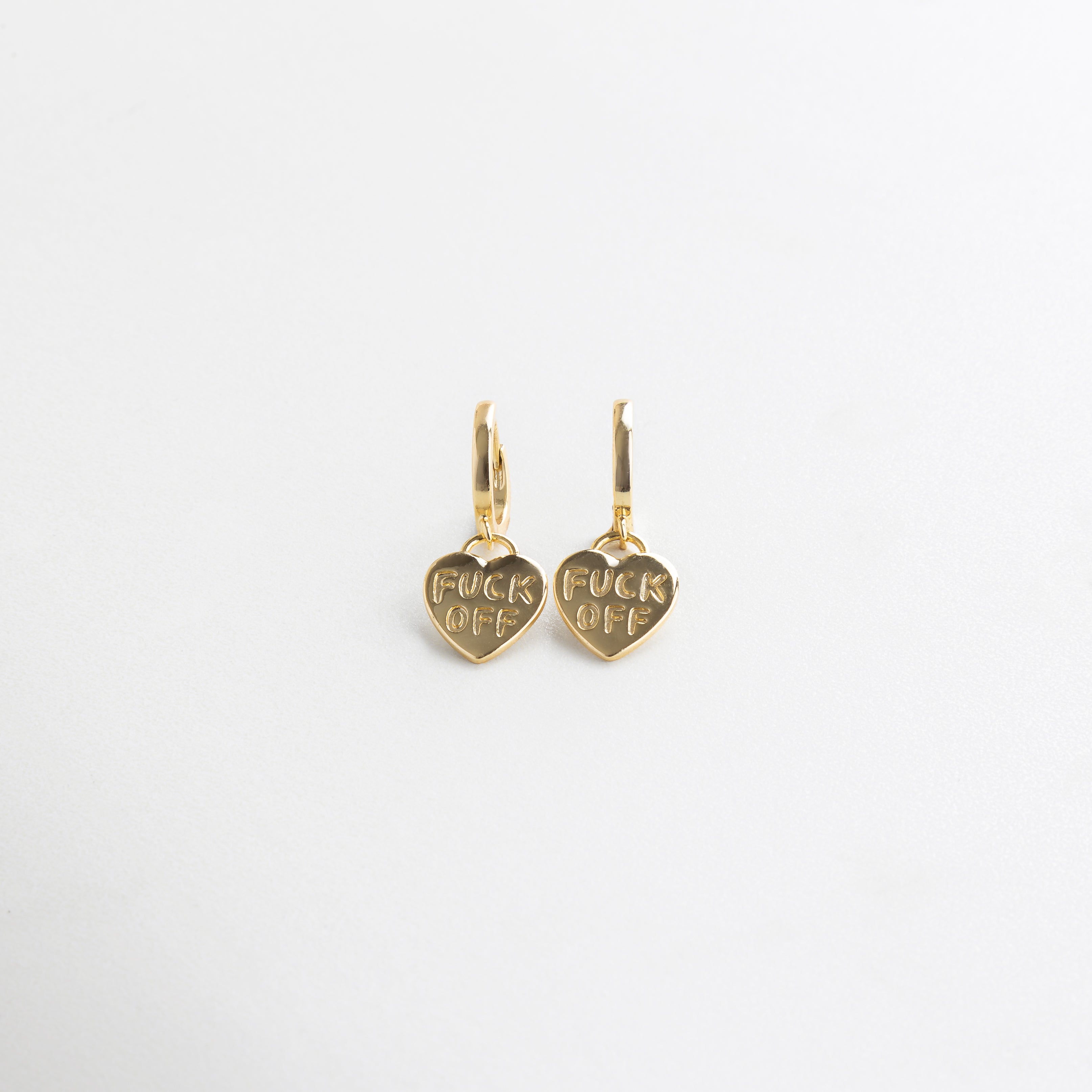 Aretes dorados en forma de corazón con grabado Fuck Off, Aretes con mensaje irreverente en corazón dorado, Fuck Off Hoops dorados con diseño punk y acabado brillante, Aretes con actitud en forma de corazón con grabado