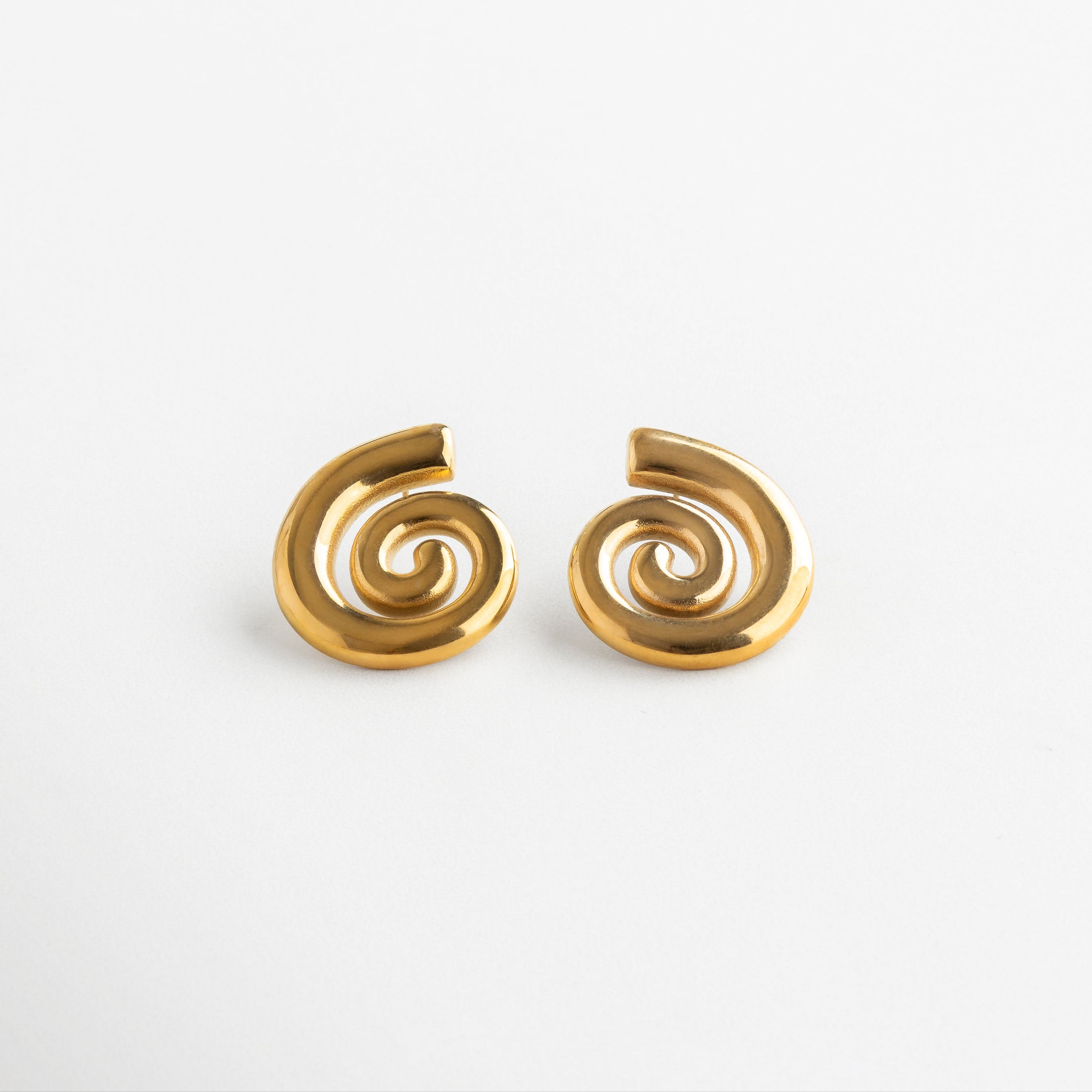 Aretes en espiral dorados con diseño moderno y fluido, Aretes escultóricos con forma de espiral en baño de oro 18K, Par de aretes dorados con silueta en espiral y acabado brillante, Aretes Espirales con diseño artístico y forma envolvente

